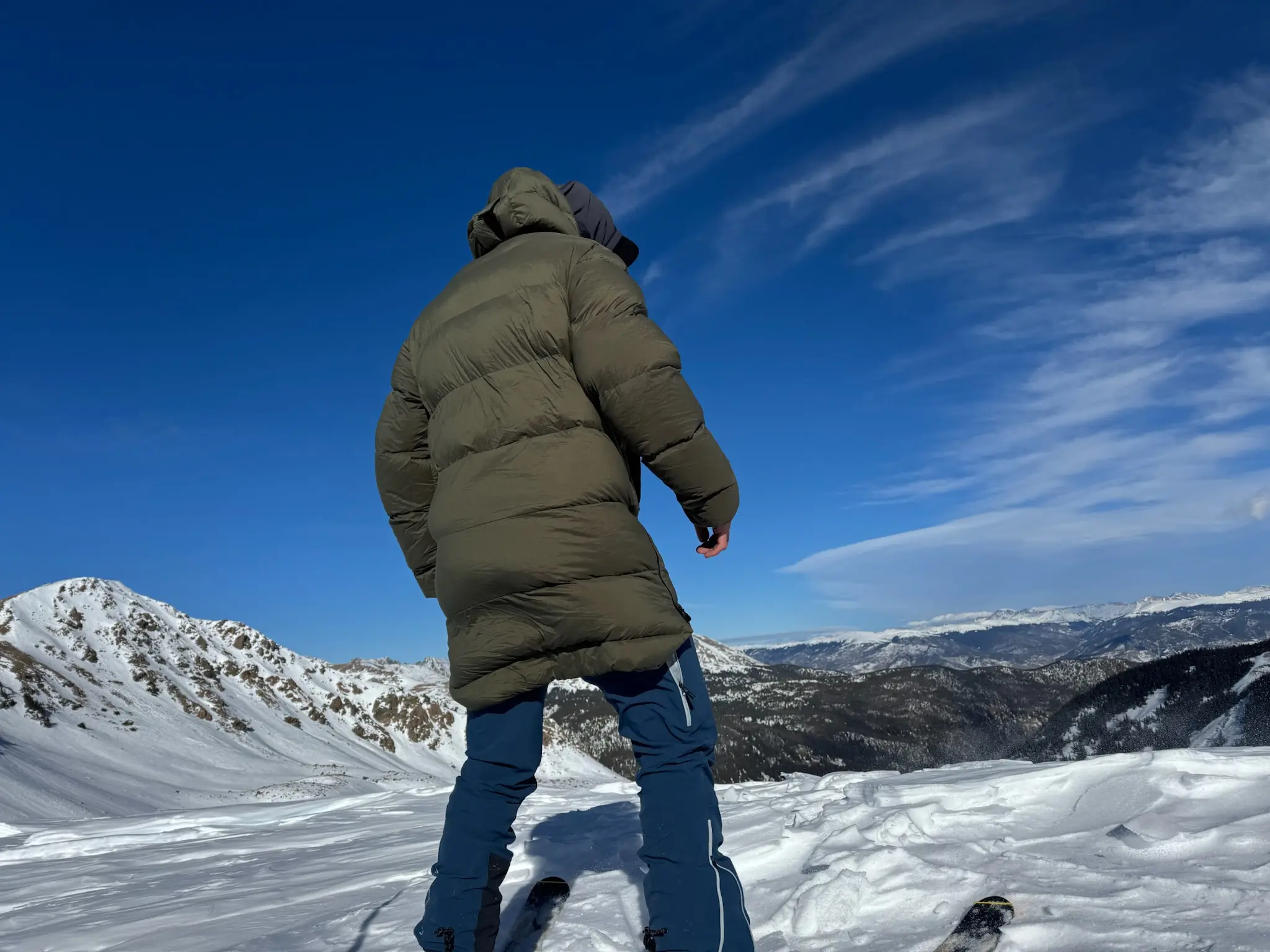 Back view of the Stellar Free Down Parka on a snowy mountain ridge