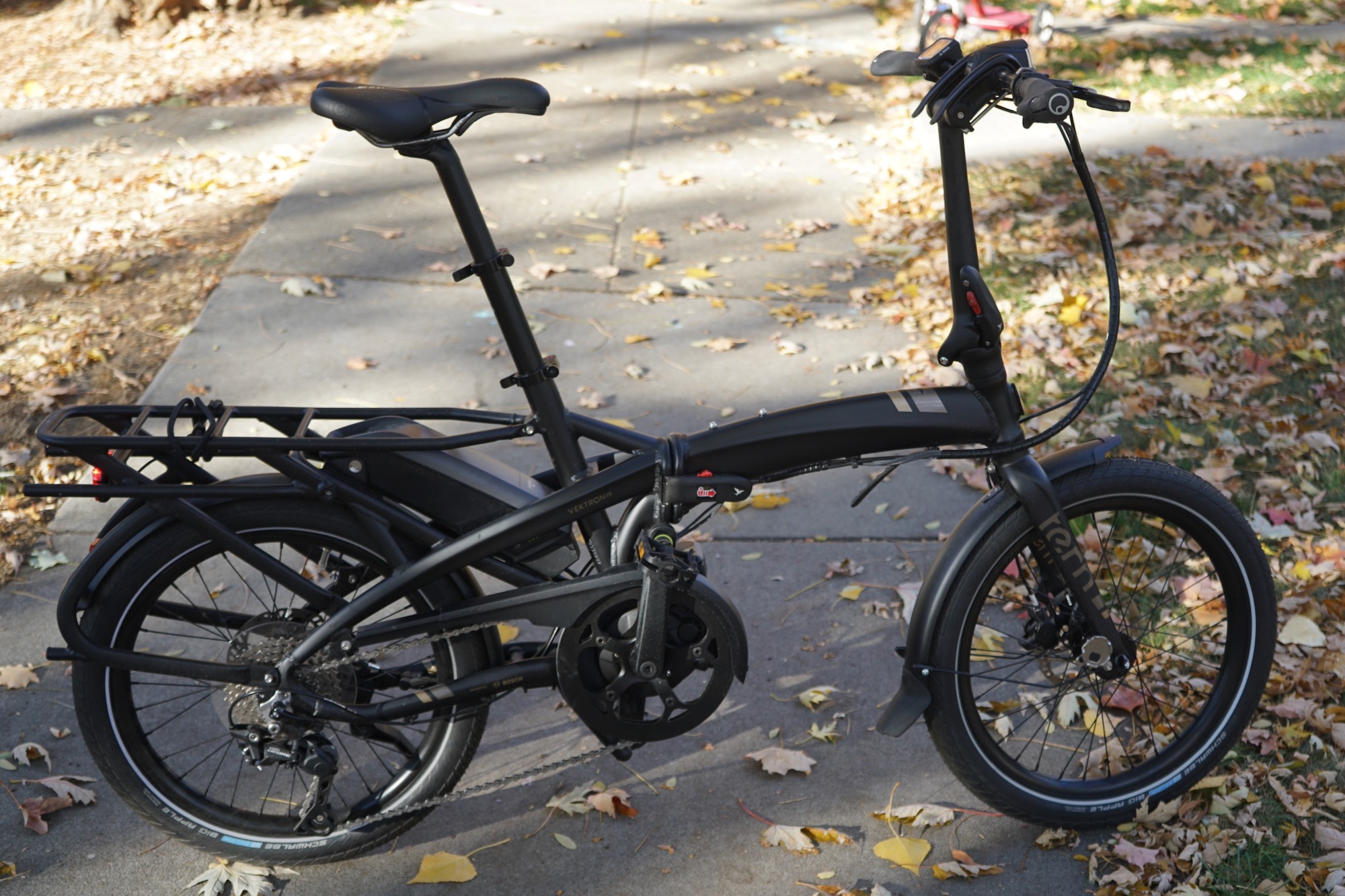 The Tern Vektron S10 folding electric bike parked on a sidewalk.