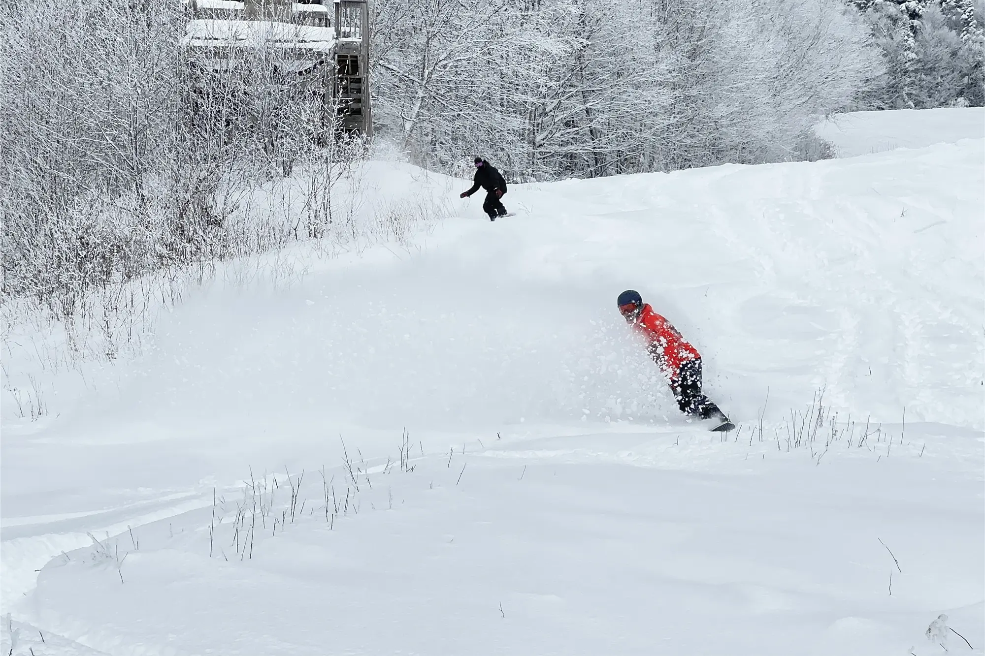 Snowboarder kicking up powder in the Arc'teryx Sabre 3L jacket