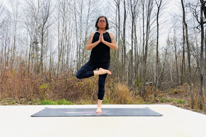 Woman practicing yoga outdoors on a yoga mat