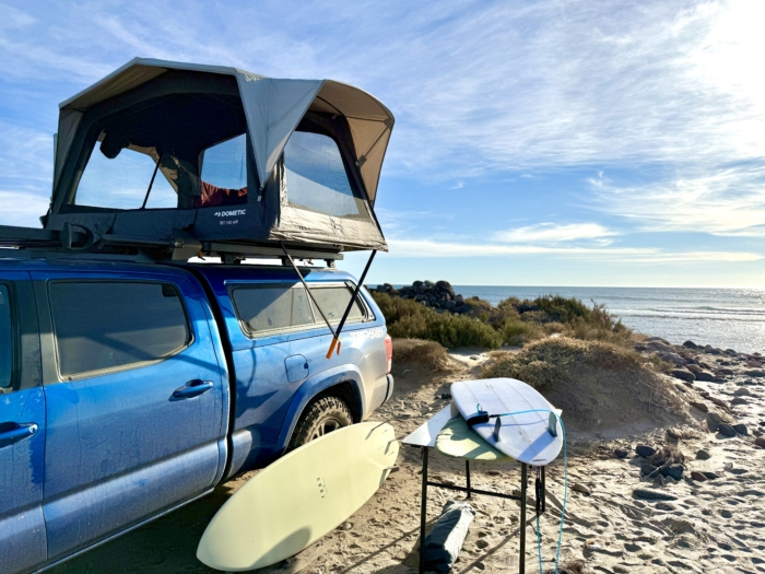 the Dometic TRT 140 Air Inflatable Rooftop Tent with the Dometic aluminum camp table and surfboards