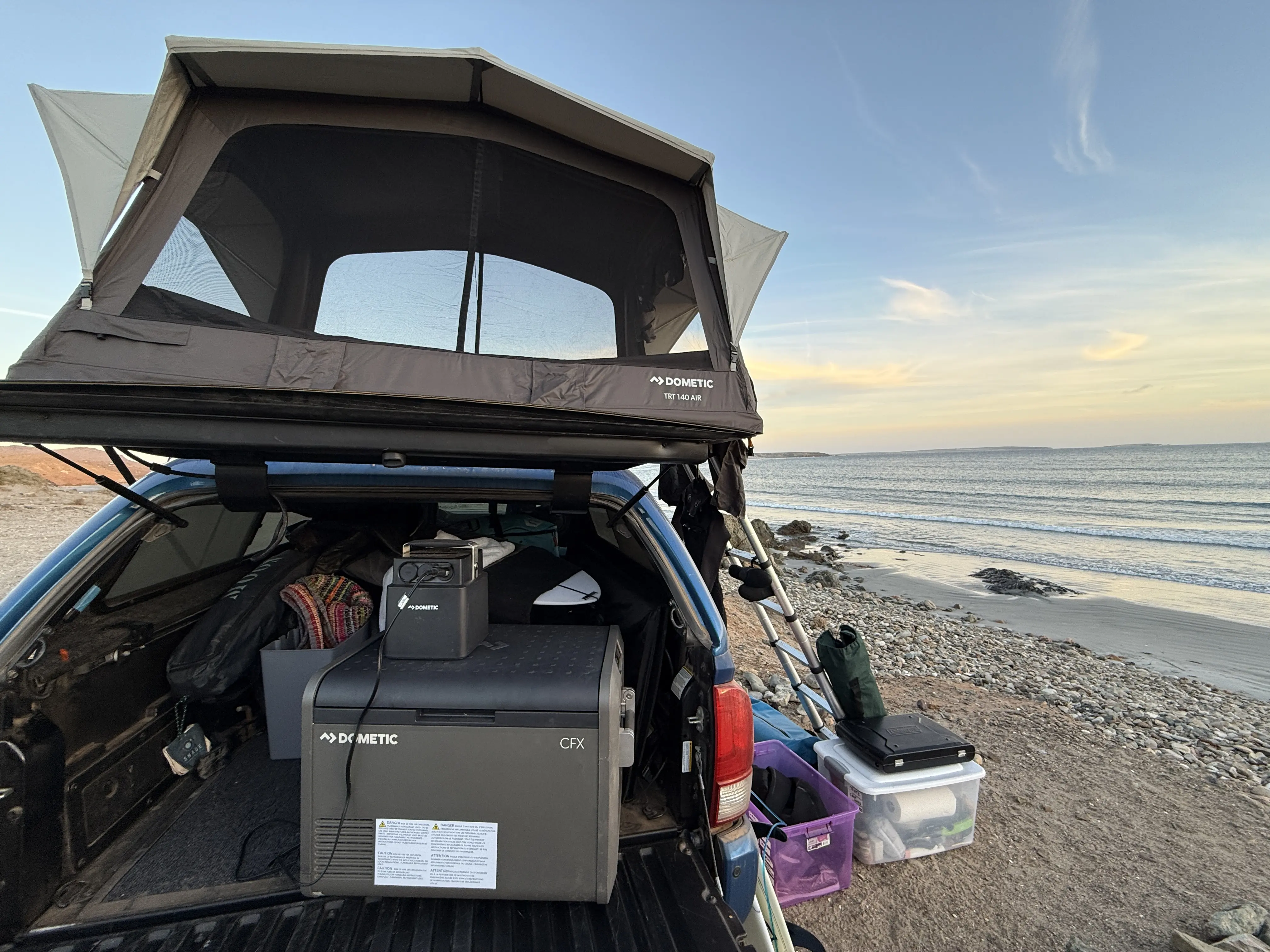 Dometic CFX 55 in back of truck bed inside topper with beach in view 