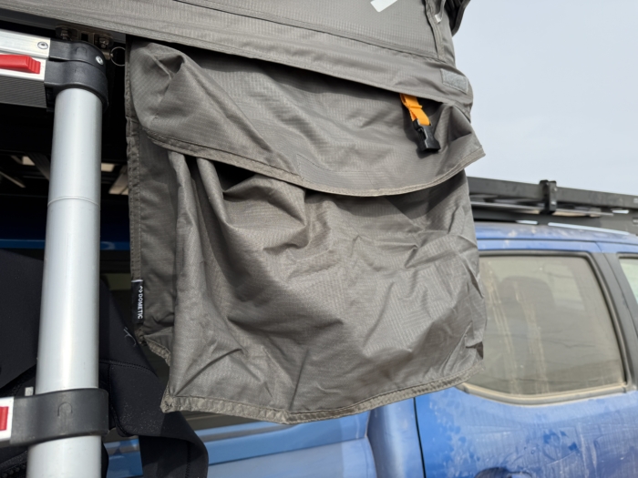 The included exterior pockets of the Dometic TRT 140 Air Inflatable Rooftop Tent