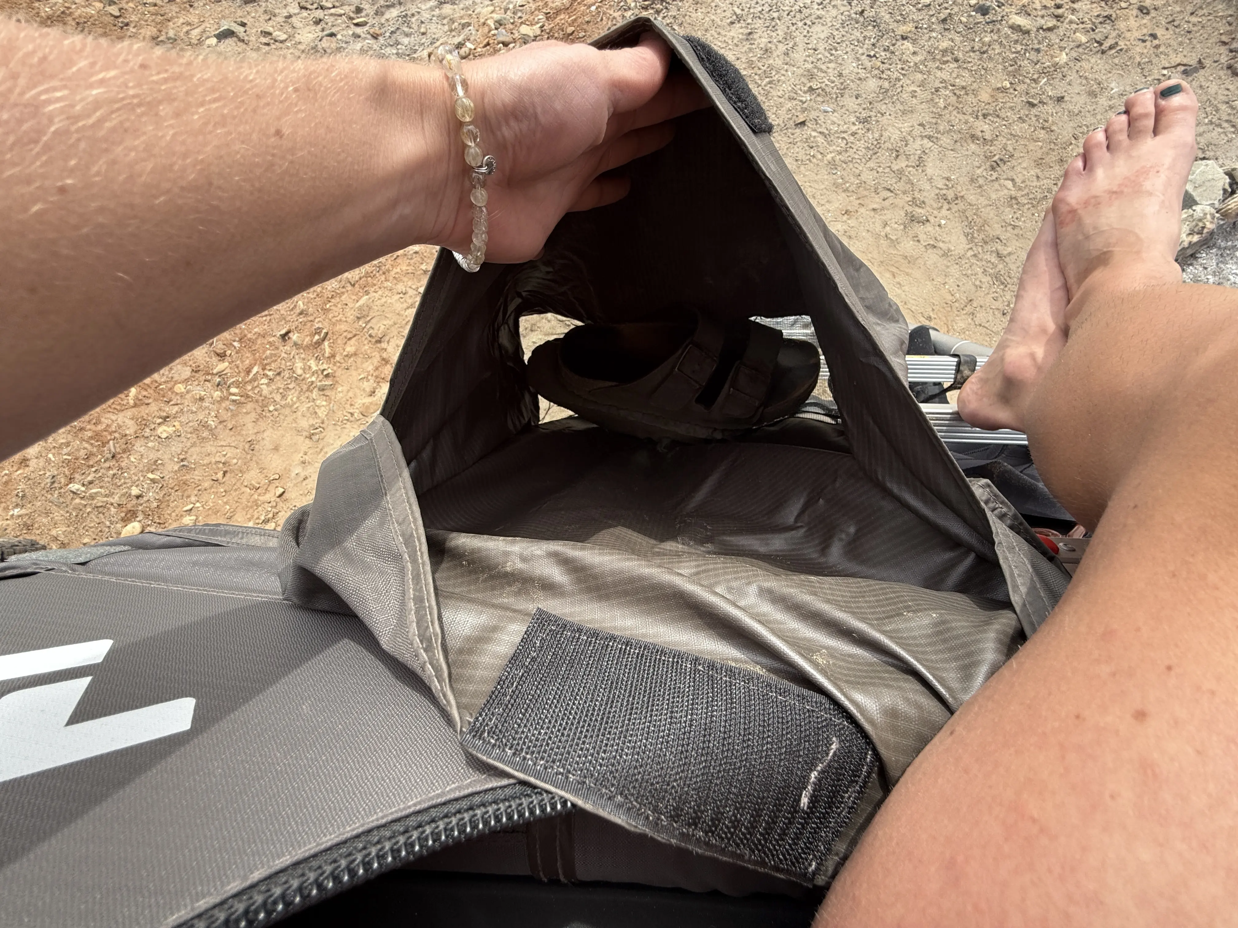 Shoes inside the included exterior pocket of the Dometic TRT 140 Air Inflatable Rooftop Tent