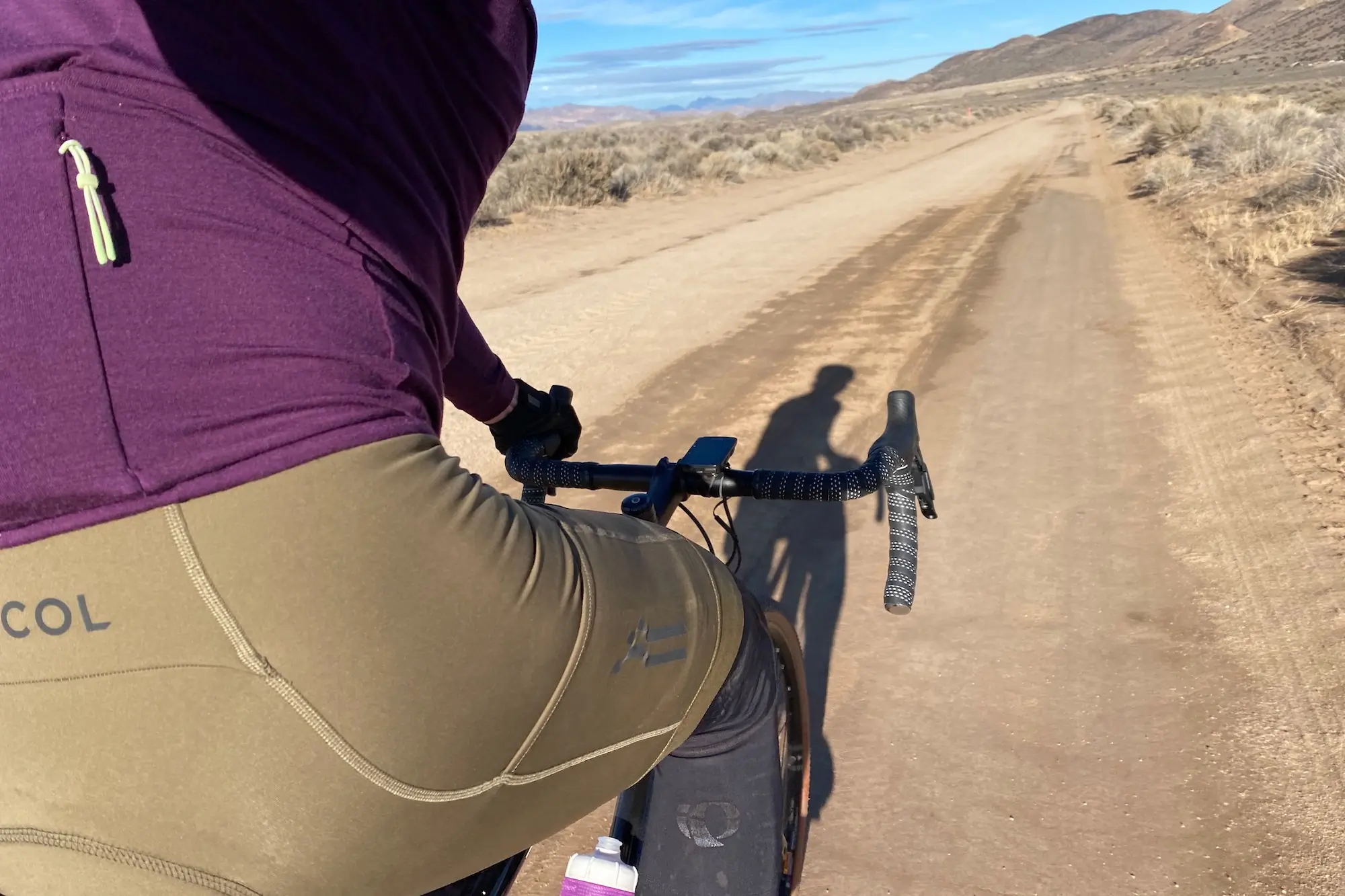 Riding in the Le Col ARC Cargo Bib Sorts and Merino Long Sleeve jersey on a gravel road in Northern Nevada