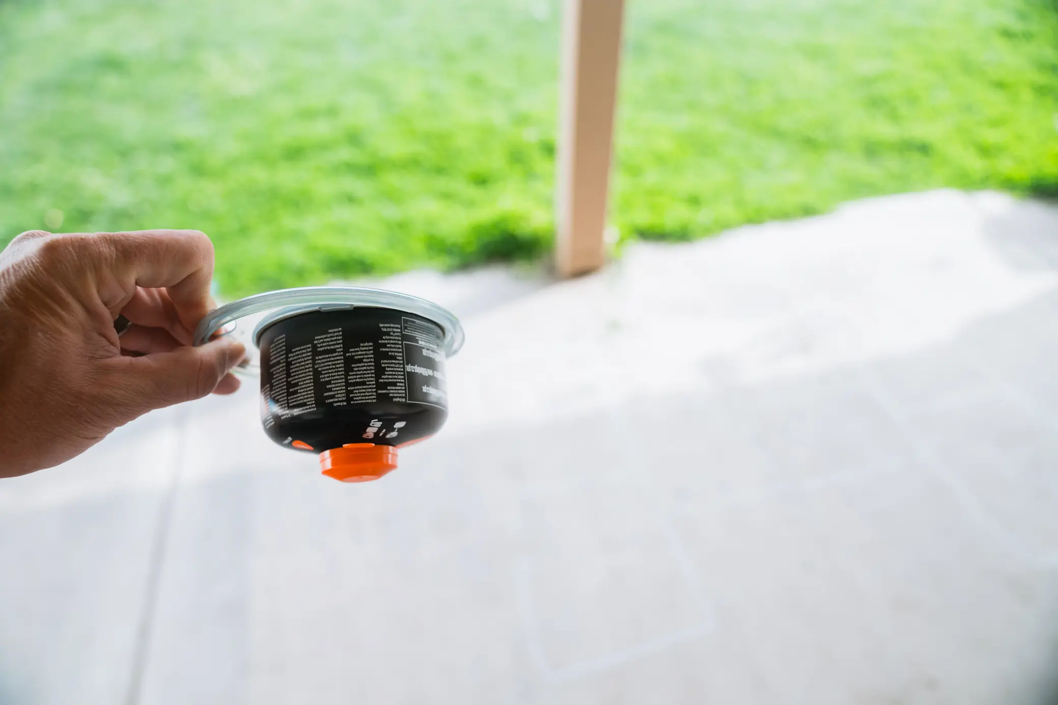 A hand holding a Jetboil fuel canister with a transparent lid, showcasing its compact and portable design
