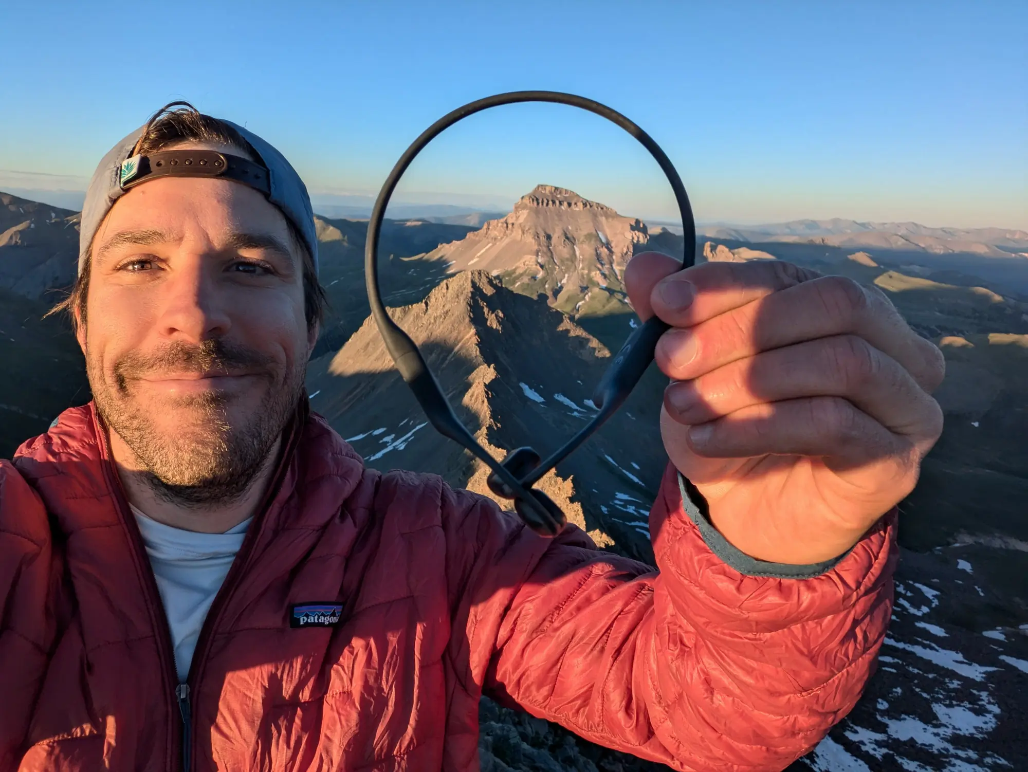 the author holding the shokz headphones up, showing how relatively compact they are