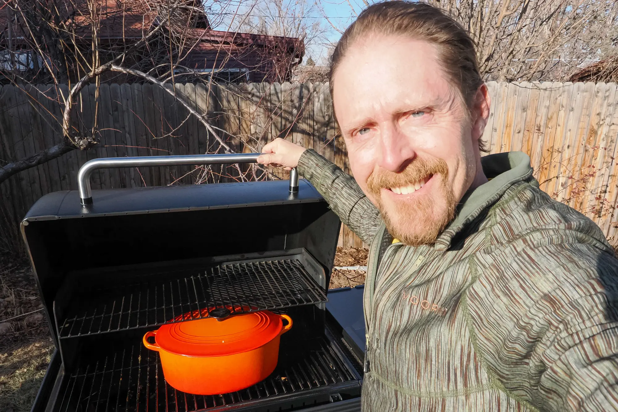 Man with Traeger Woodridge grill open