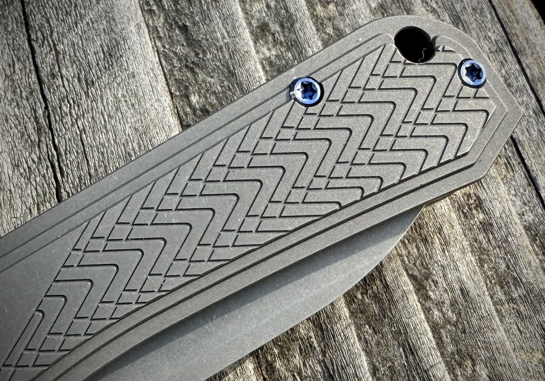 Close-up of the WE Knife Bougie Banter handle, highlighting its precise textured pattern and blue-accented screws