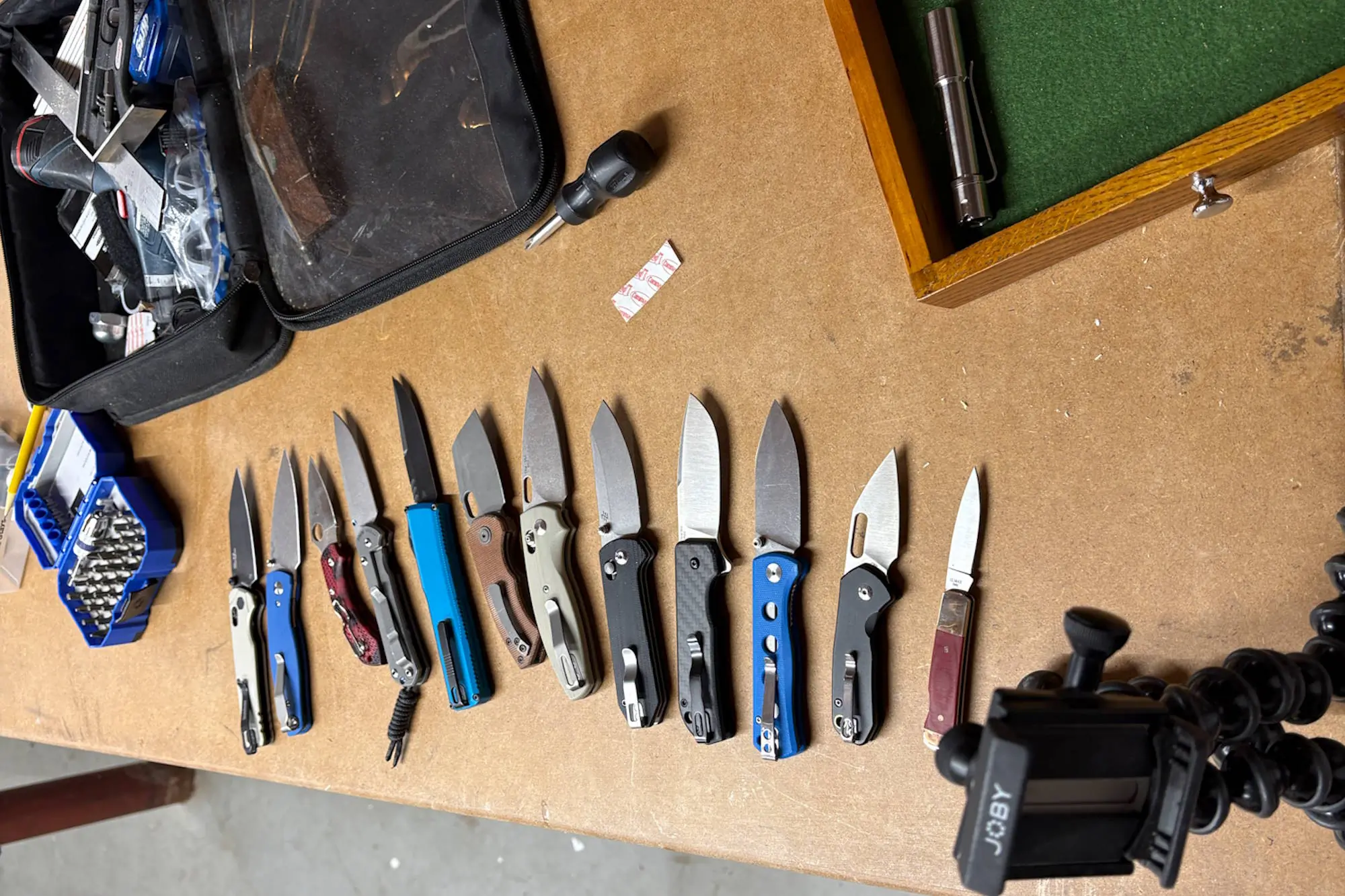 multipe knives arranged on table with tools and gears