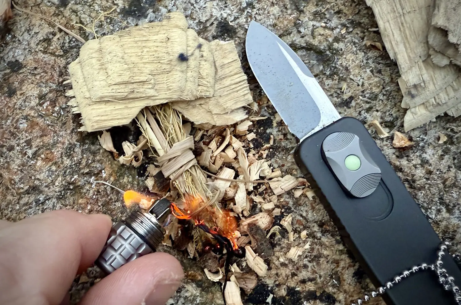 Close-up of a fire-starting setup with a PDW CAS OTF knife