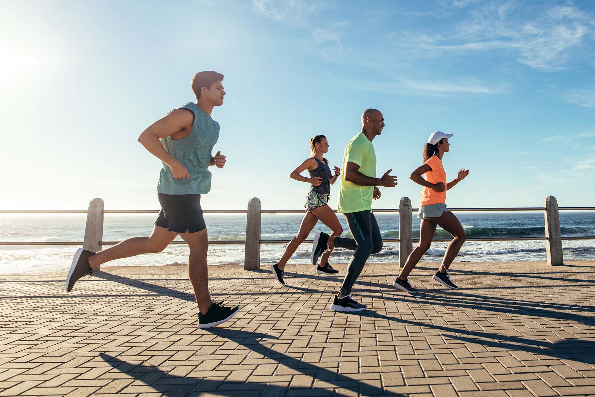Group,Of,Athletes,Running,On,Ocean,Front.,Runners,In,Sportswear