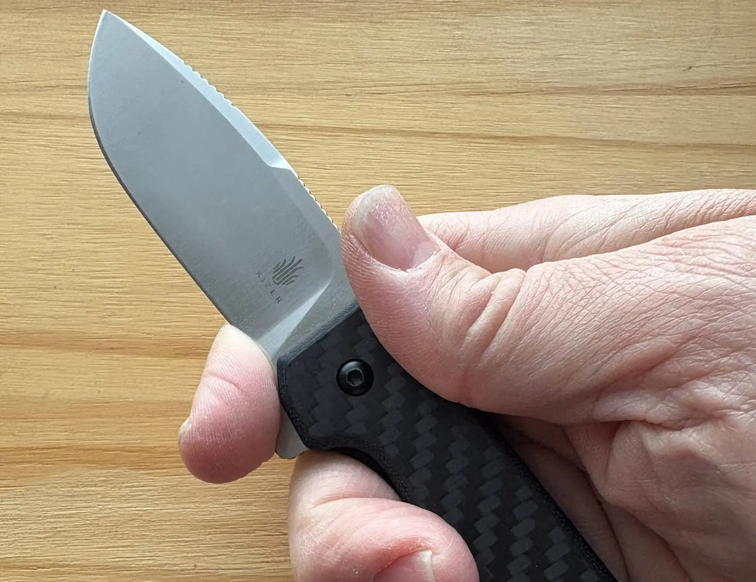 hand holding kizer nice guy knife