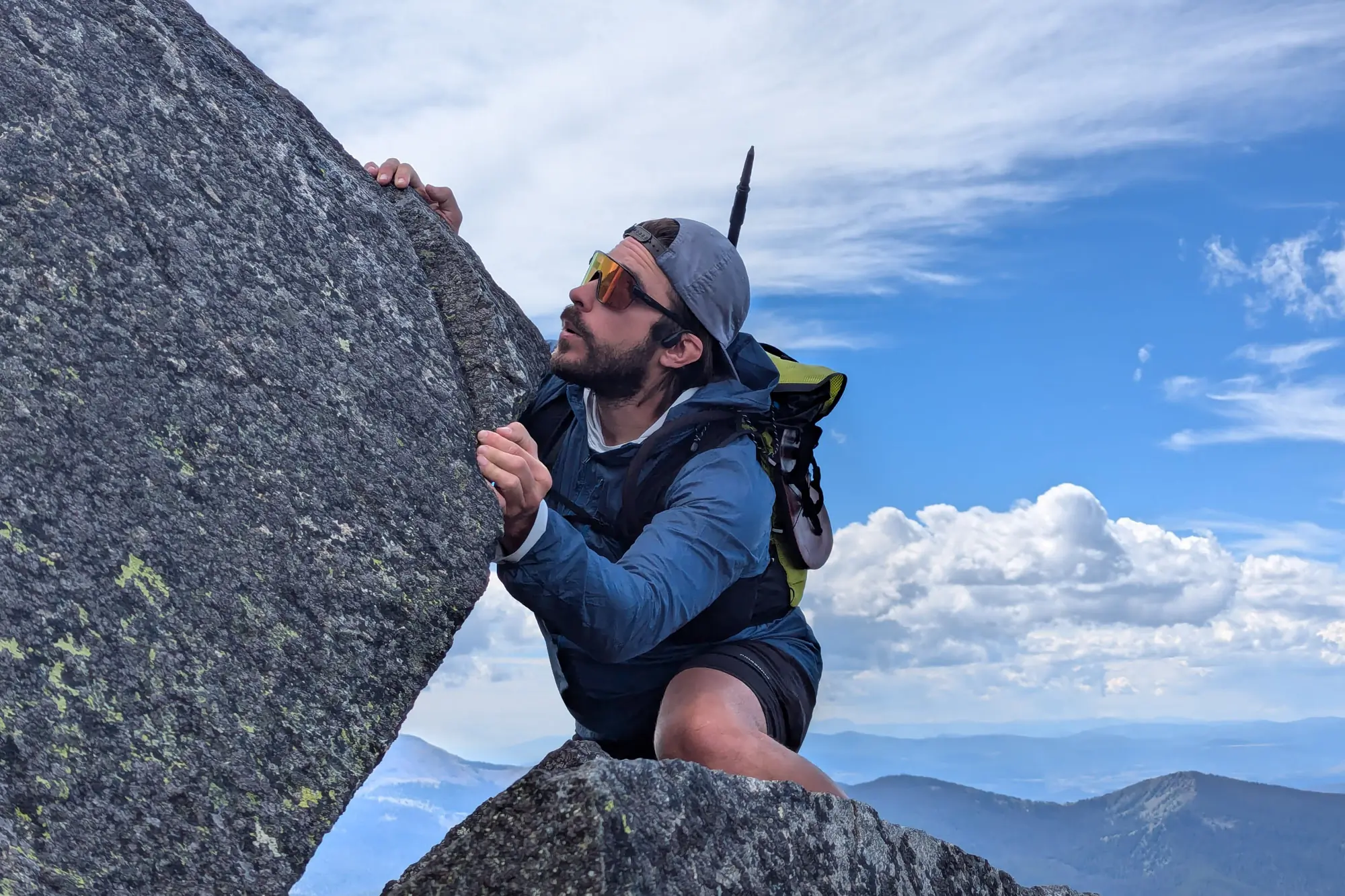 the author scrambling in the alpine while wearing the shokz headphones