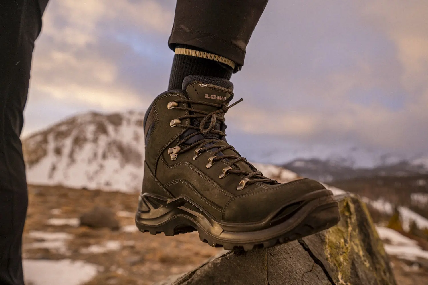 Closeup of person wearing lowa renegade boots on a rocky surface