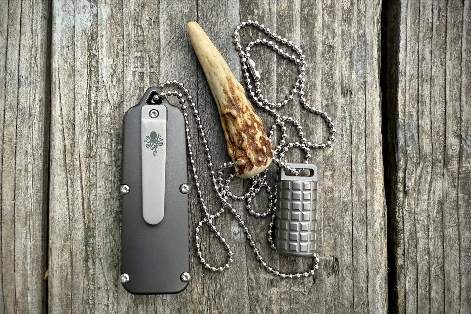 PDW SPD CAS OTF knife with a lighter, displayed on a wooden surface