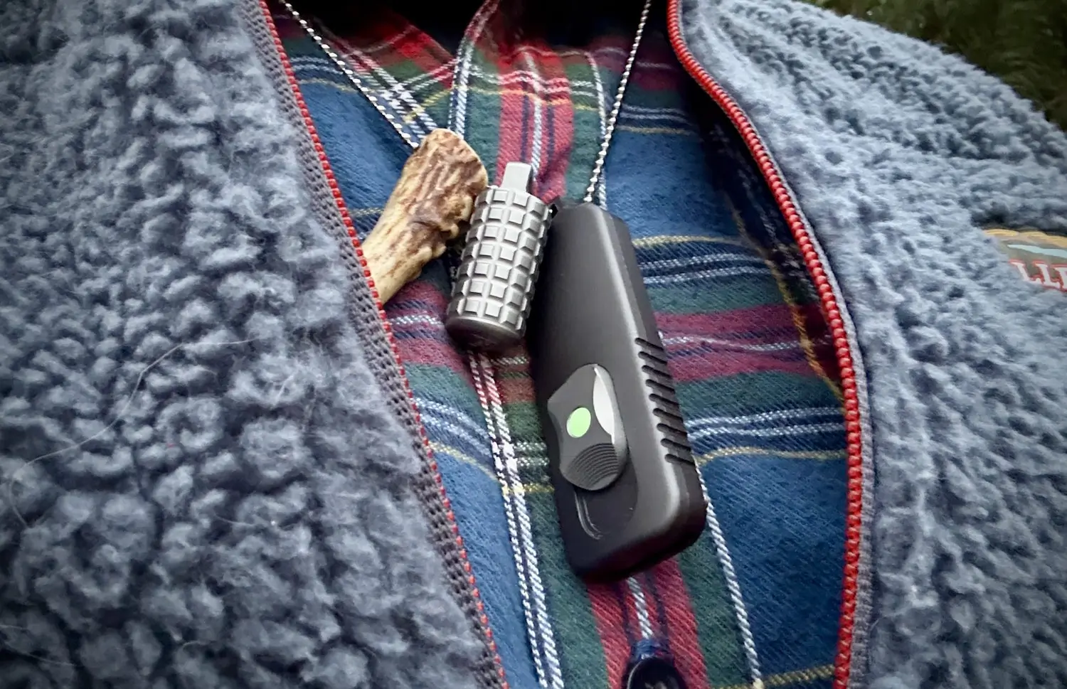 Man wearing a necklace holding a compact lighter and SPD CAS OTF knife