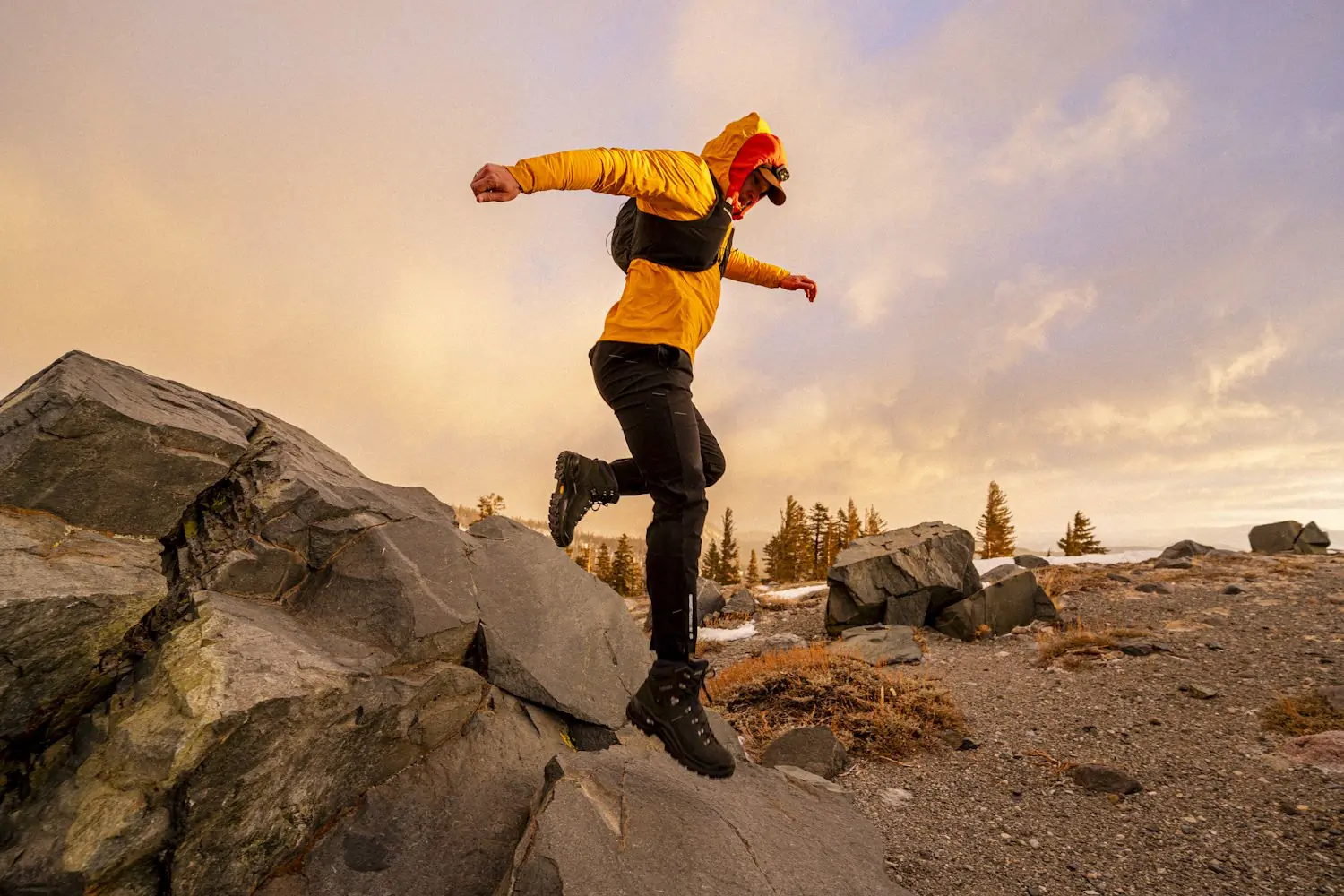 Person wearing lowa renegade hiking boots jumping off a rock