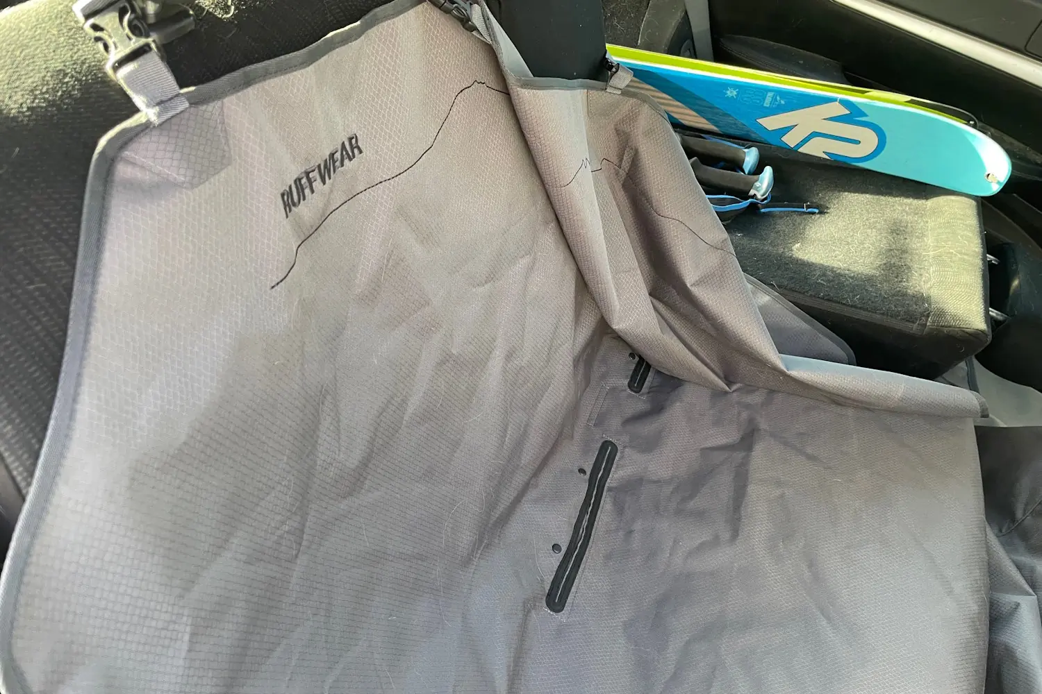 Folded-down Ruffwear car seat cover with a mountain silhouette designed to protect the back seat