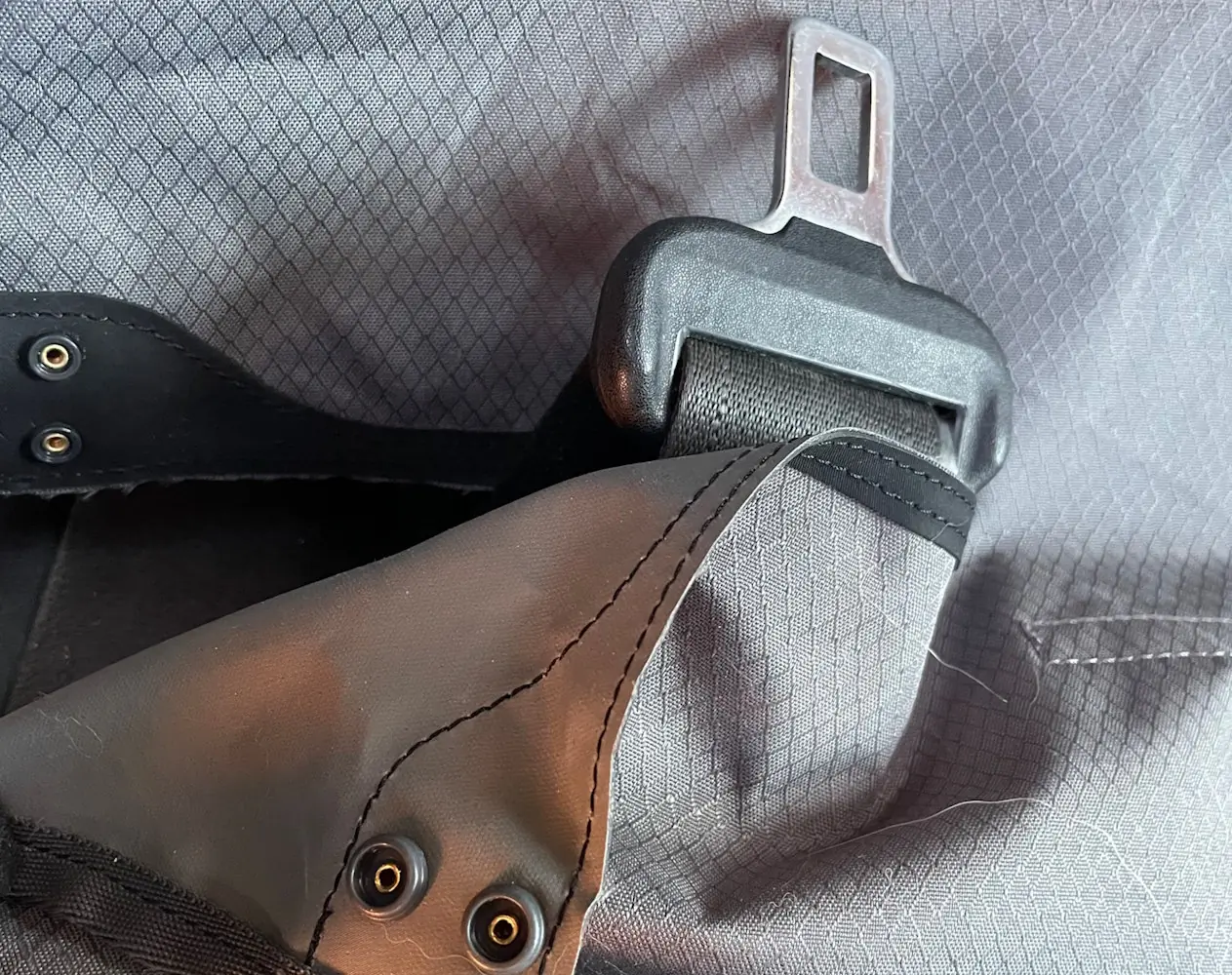 Close-up of a car seatbelt in a Ruffwear seat cover