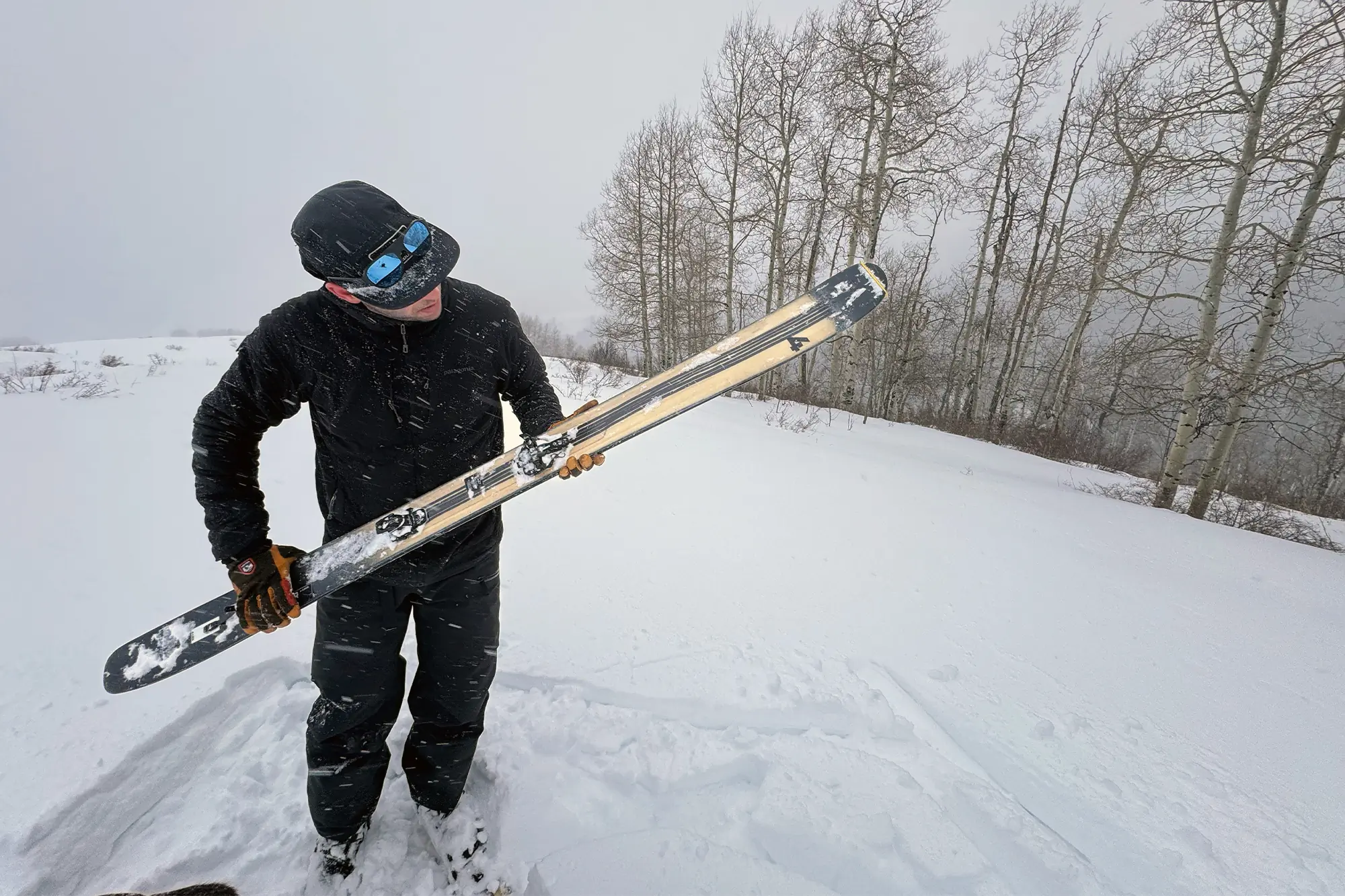 Inspecting the 4FRNT Nevar skis in stormy backcountry conditions