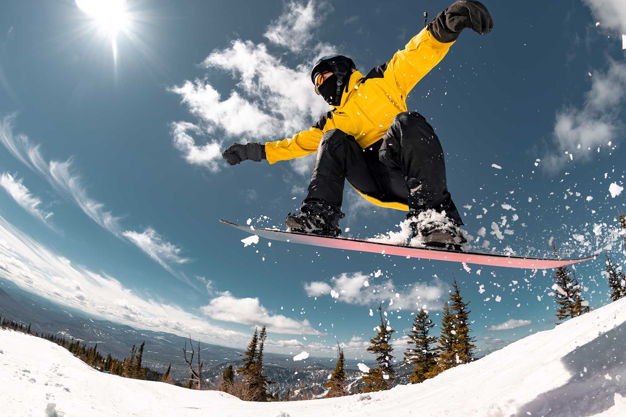Active young snowboarder jumps from the kicker at ski resort. Winter sports active weekend concept