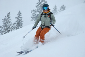 A skier carving through fresh powder, surrounded by snowfall