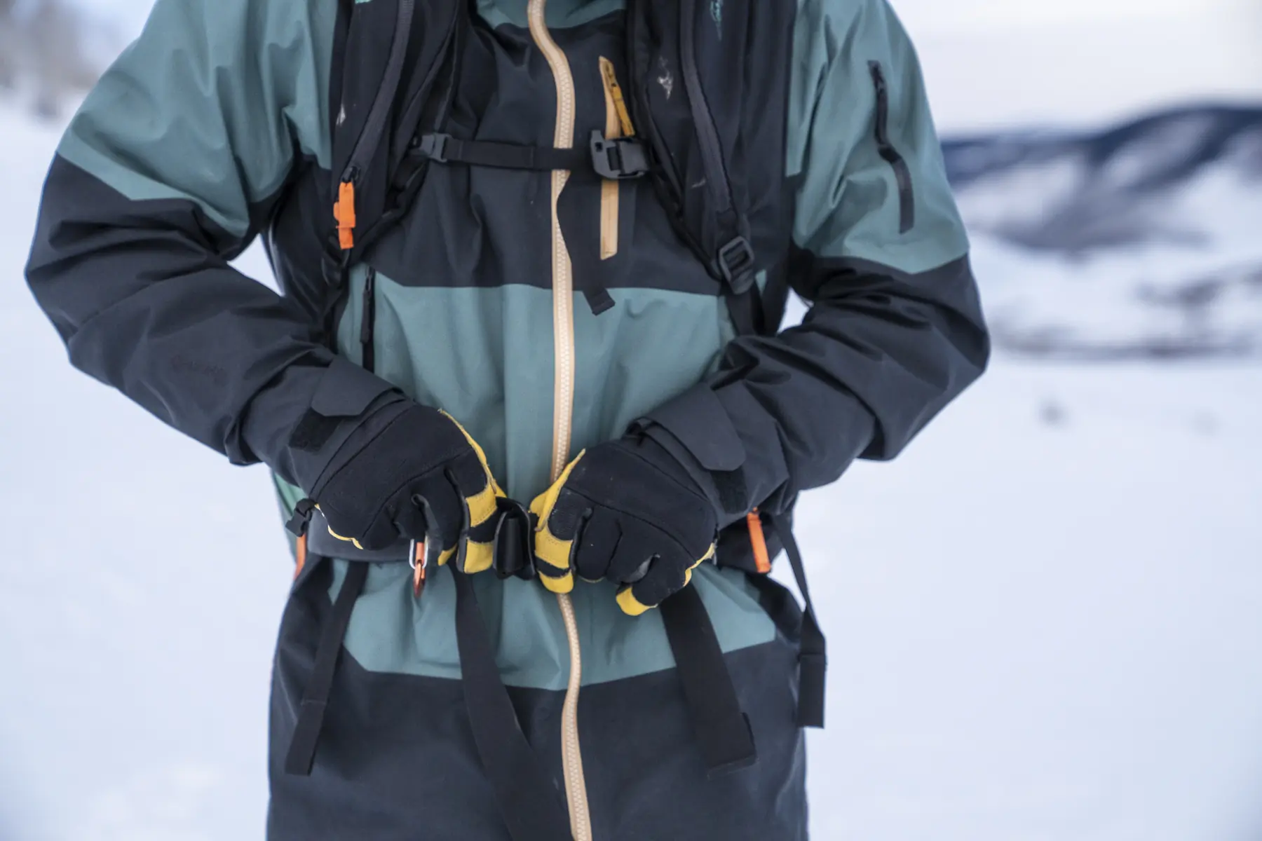 Gloved hands adjusting the waist buckle of the BCA Float E2-35 Avalanche Airbag