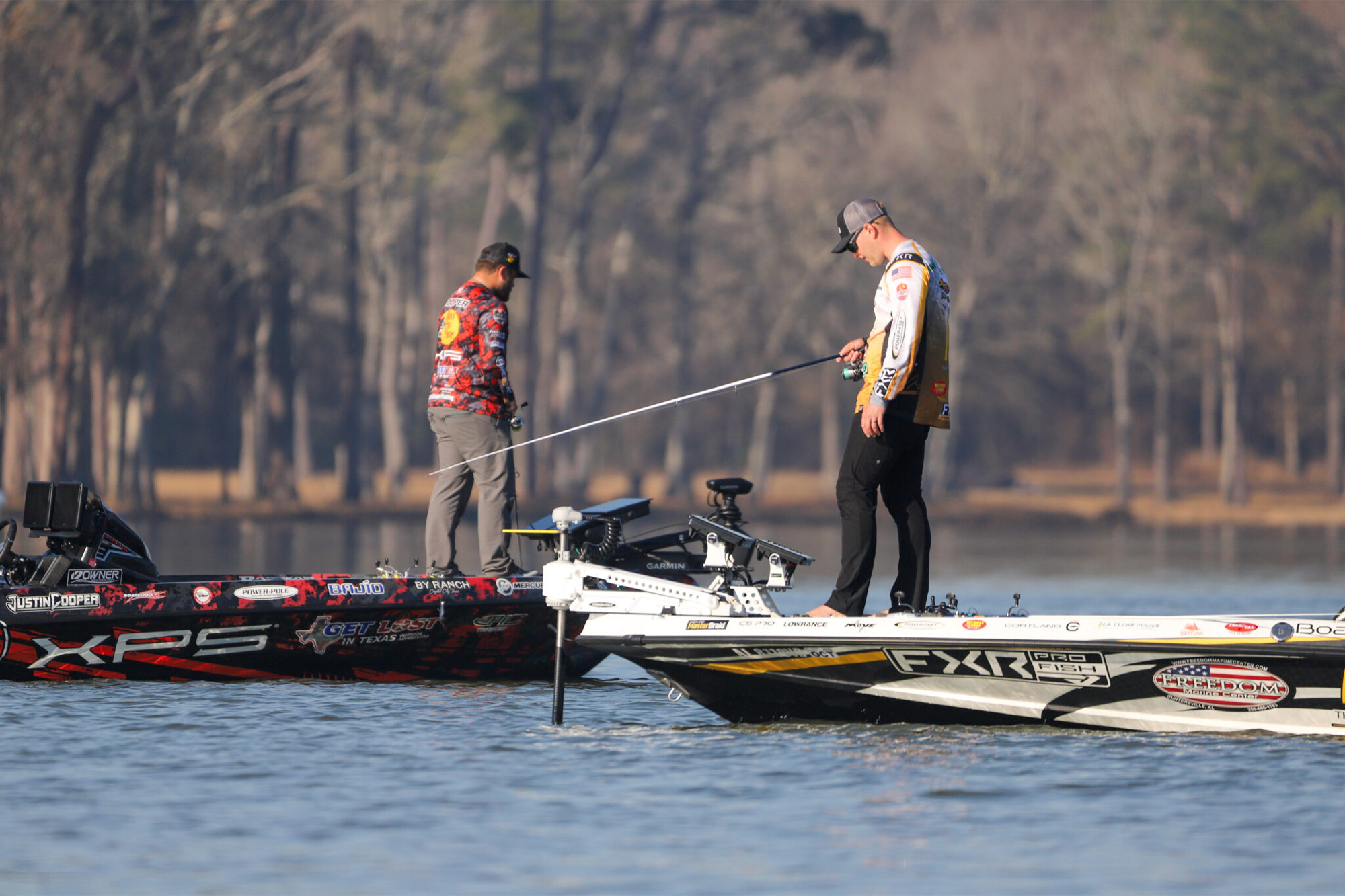 Two anglers focus on their casts in close competition on the water