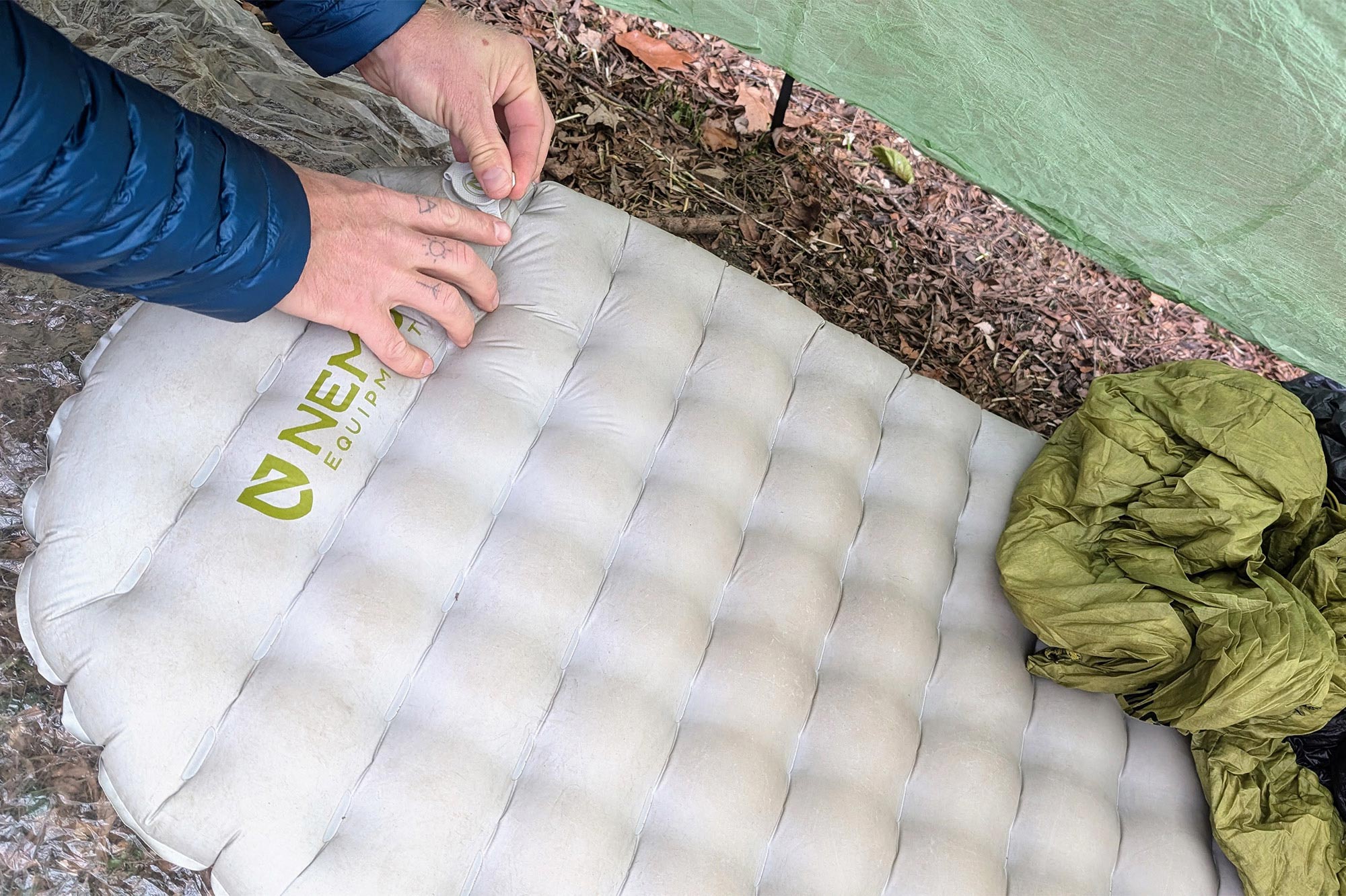 Hand deflating the NEMO Tensor Elite Sleeping Pad by pressing the valve
