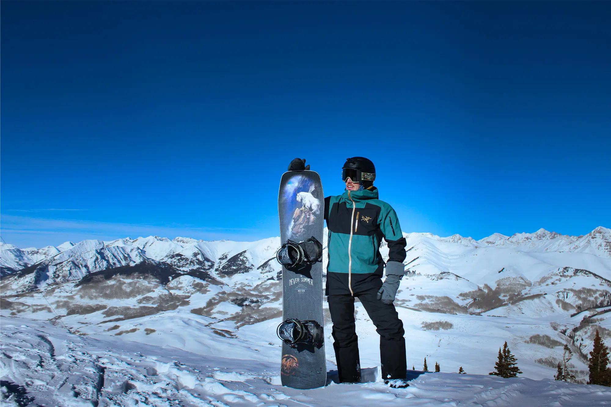 Rider Holding the Never Summer Nohku Board with Scenic Backdrop