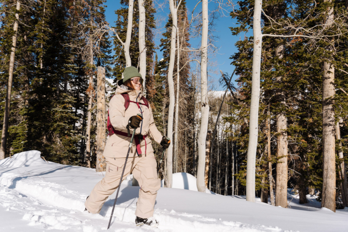 Person wearing the Trew Gear Women’s Stella Jacket PRIMO-Plus, snowshoeing through a winter forest