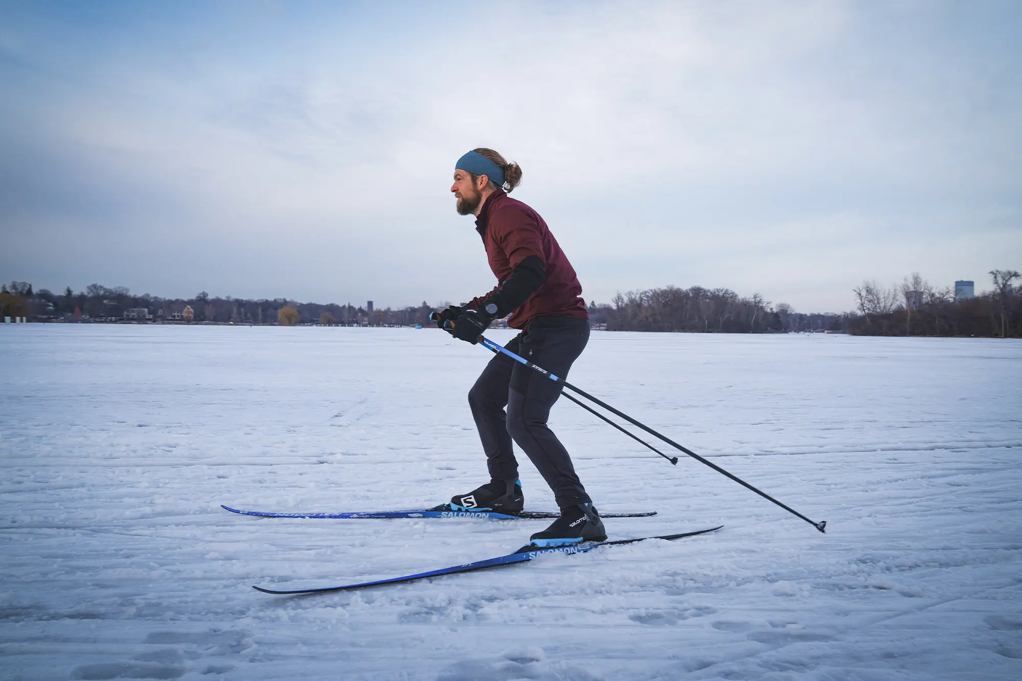 A skier glides across a frozen lake using the Salomon S/Max Skate Kit - side view