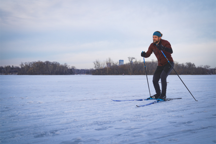 A skier moves across a frozen lake using the Salomon S/Max Skate Kit