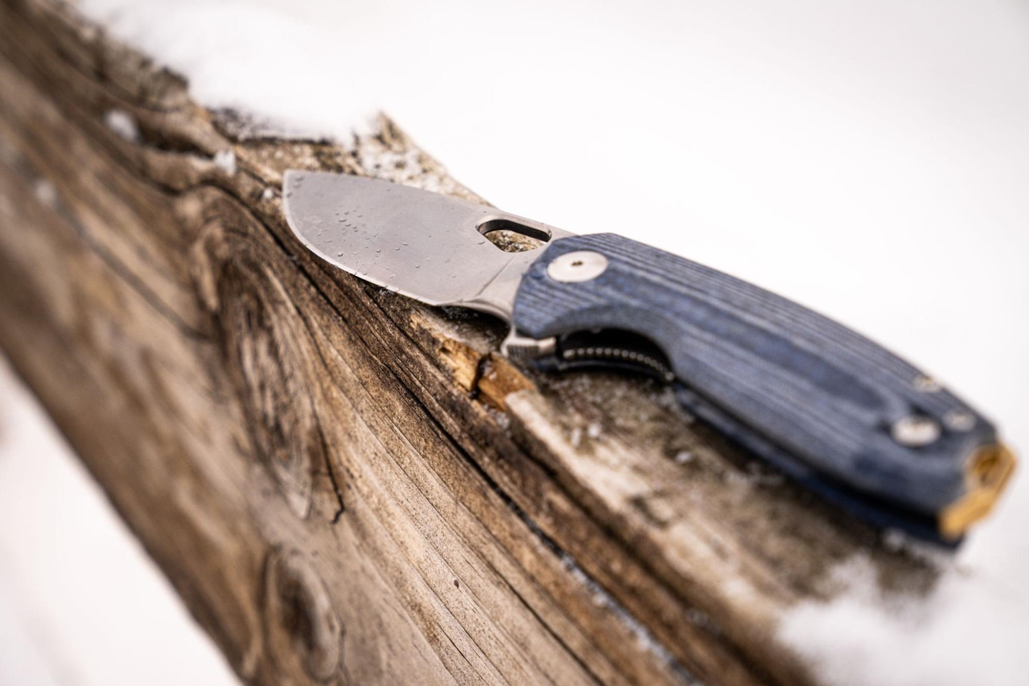 ACE Tribeca Denim Micarta knife on a wooden beam with snow