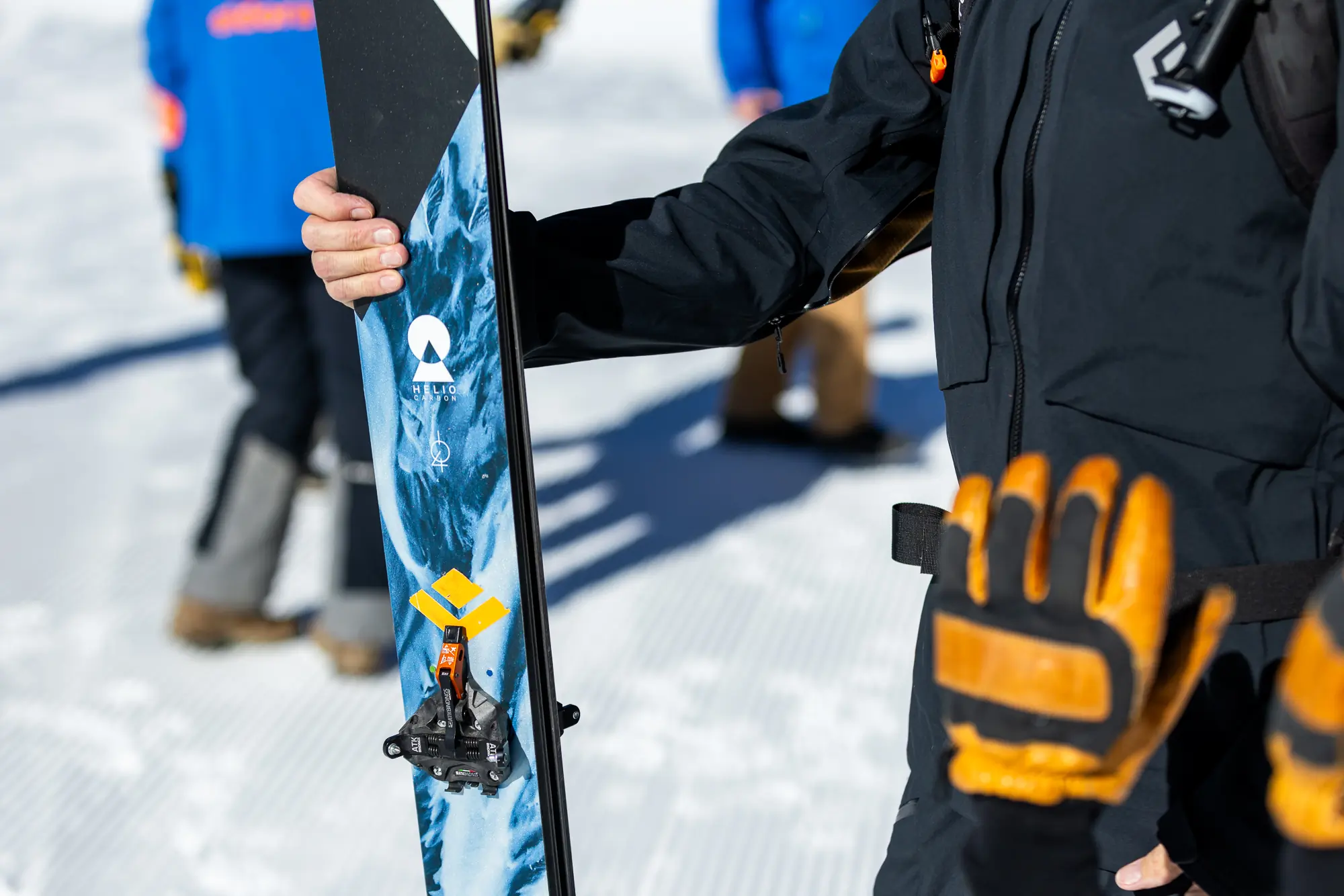 A skier holds a ski equipped with the ATK Raider 13 Evo binding