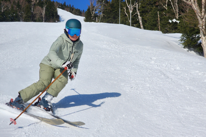 Atomic Maven 103 CTI carving through groomed snow on a sunny day