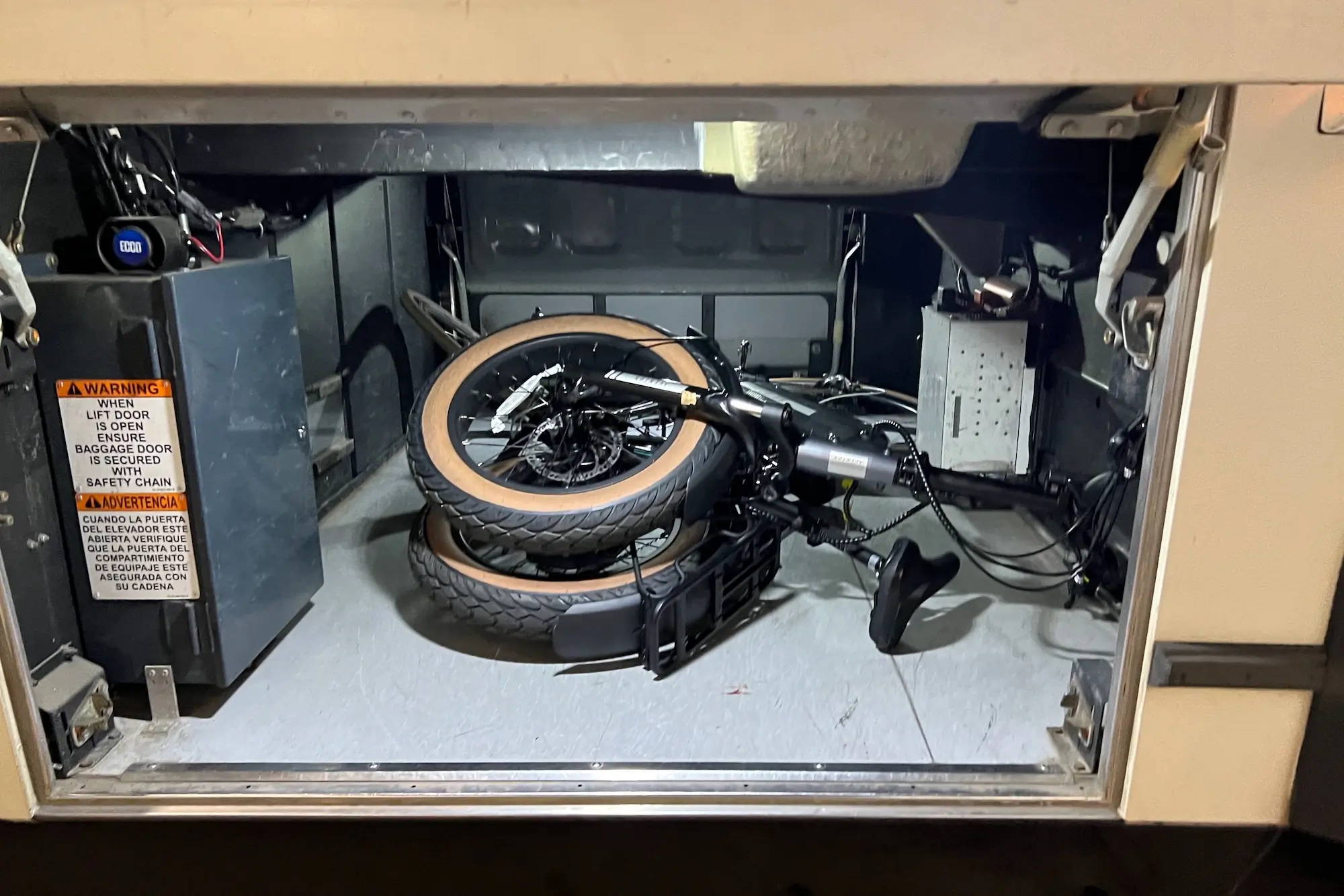 The Aventon Sinch.2 folded and stashed in a bus storage compartment