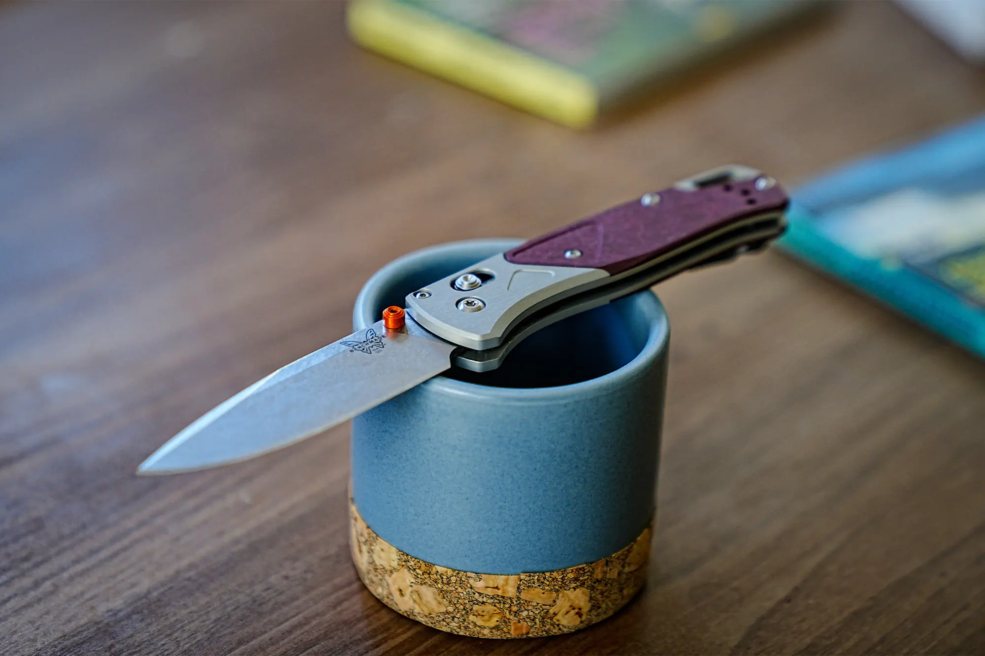 The Benchmade Bugout 535-09 is balanced on a blue mug