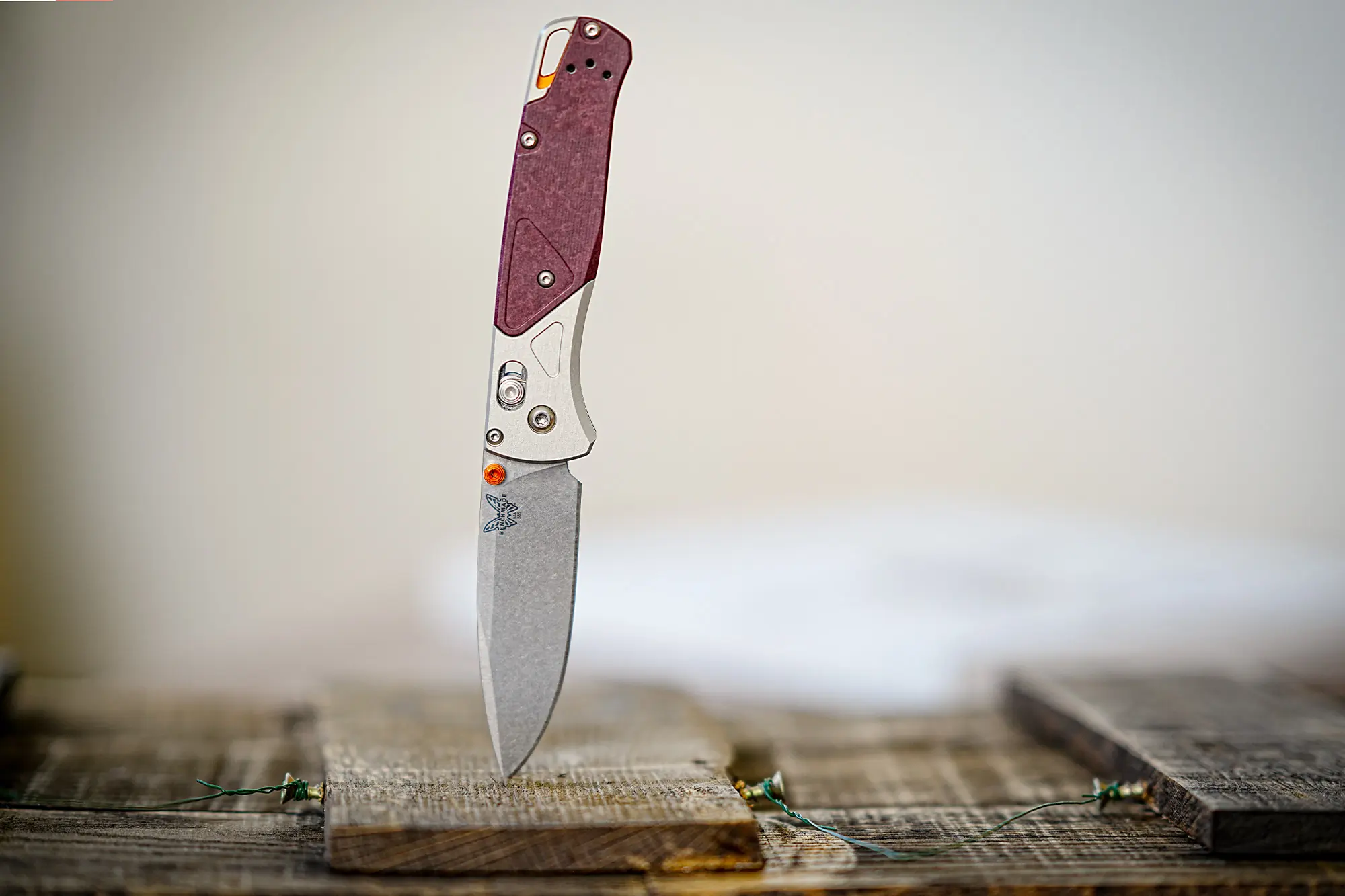 The Benchmade Bugout 535-09 stands upright on a wooden surface