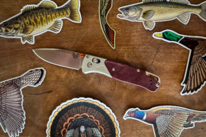 The Benchmade Bugout 535-09 is surrounded by wildlife-themed stickers
