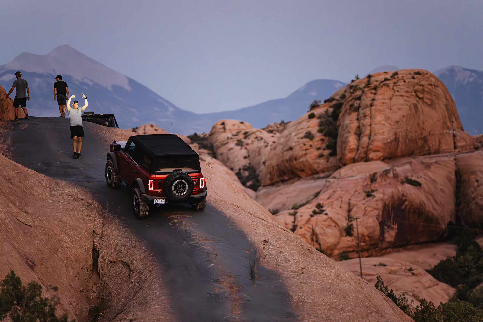 Man directs a Bronco up a rock offroad trail