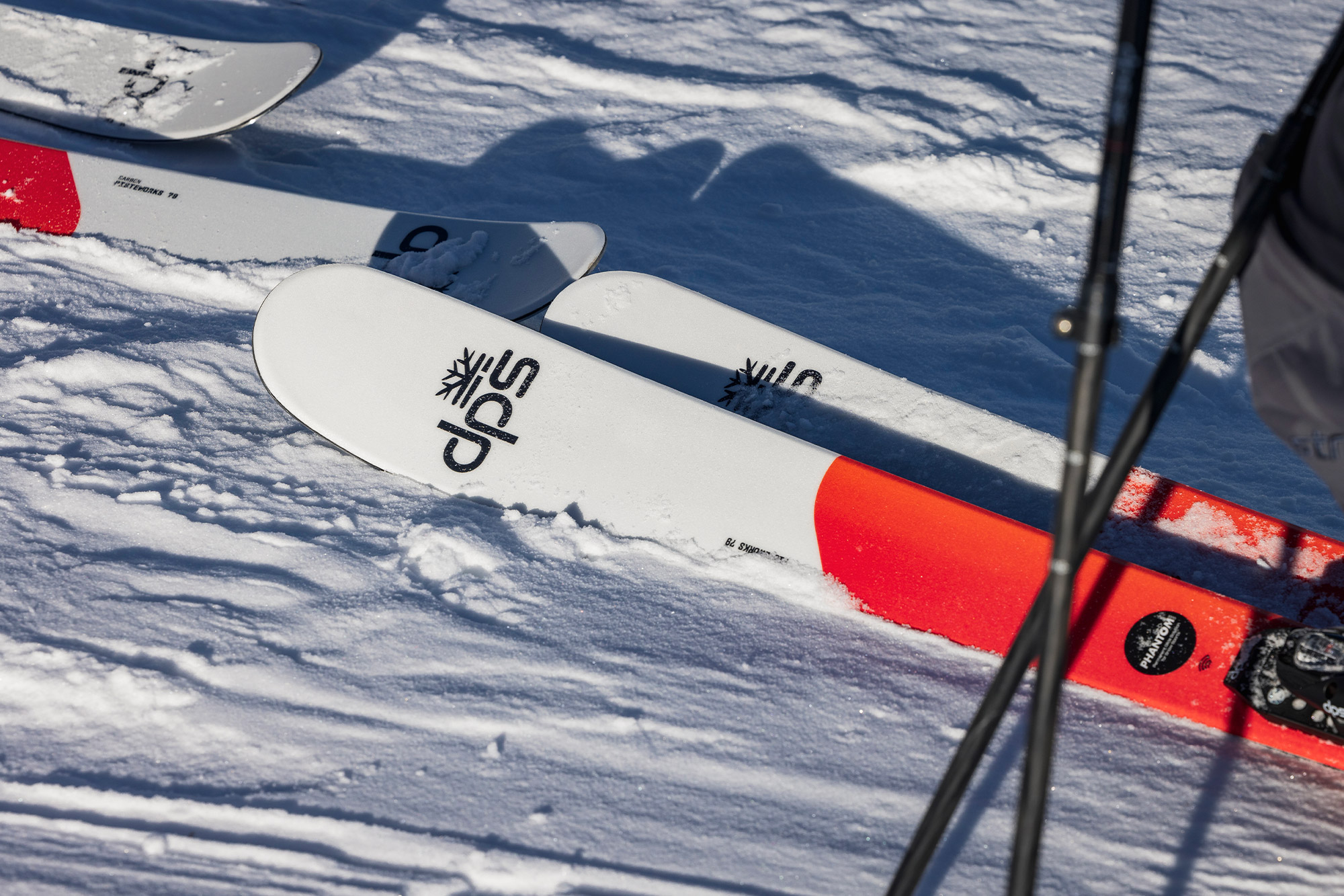 Close-up of DPS Pisteworks 79 skis resting on the snow, showing the logo