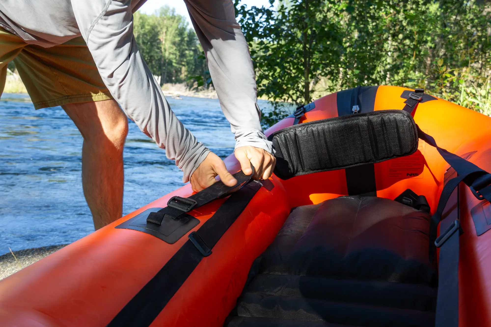 A paddler adjusts the seat on the NRS Neutron packraft