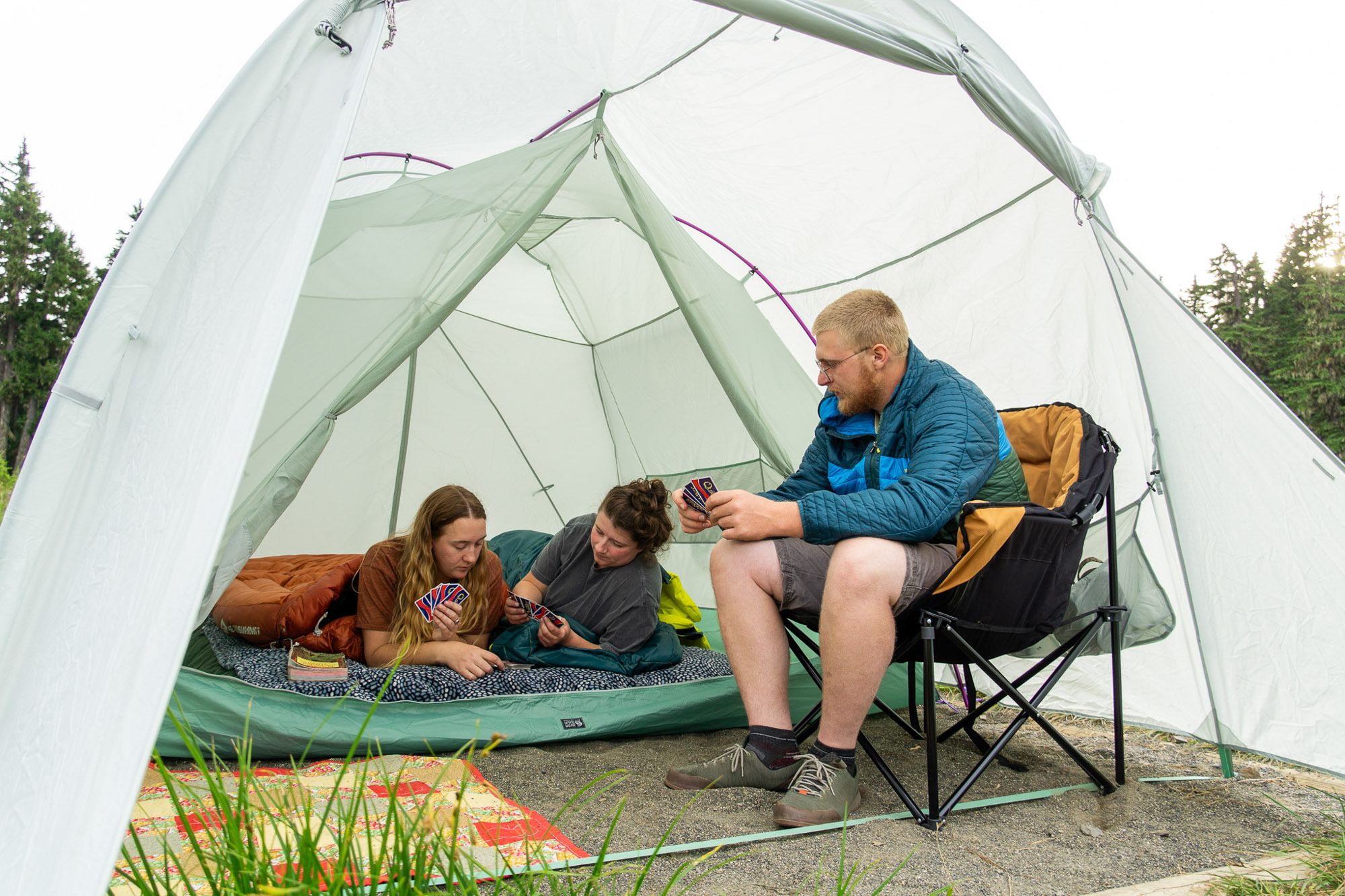 gearjunkie testers sit in the mountain hardwear bridger 6 tent playing cards