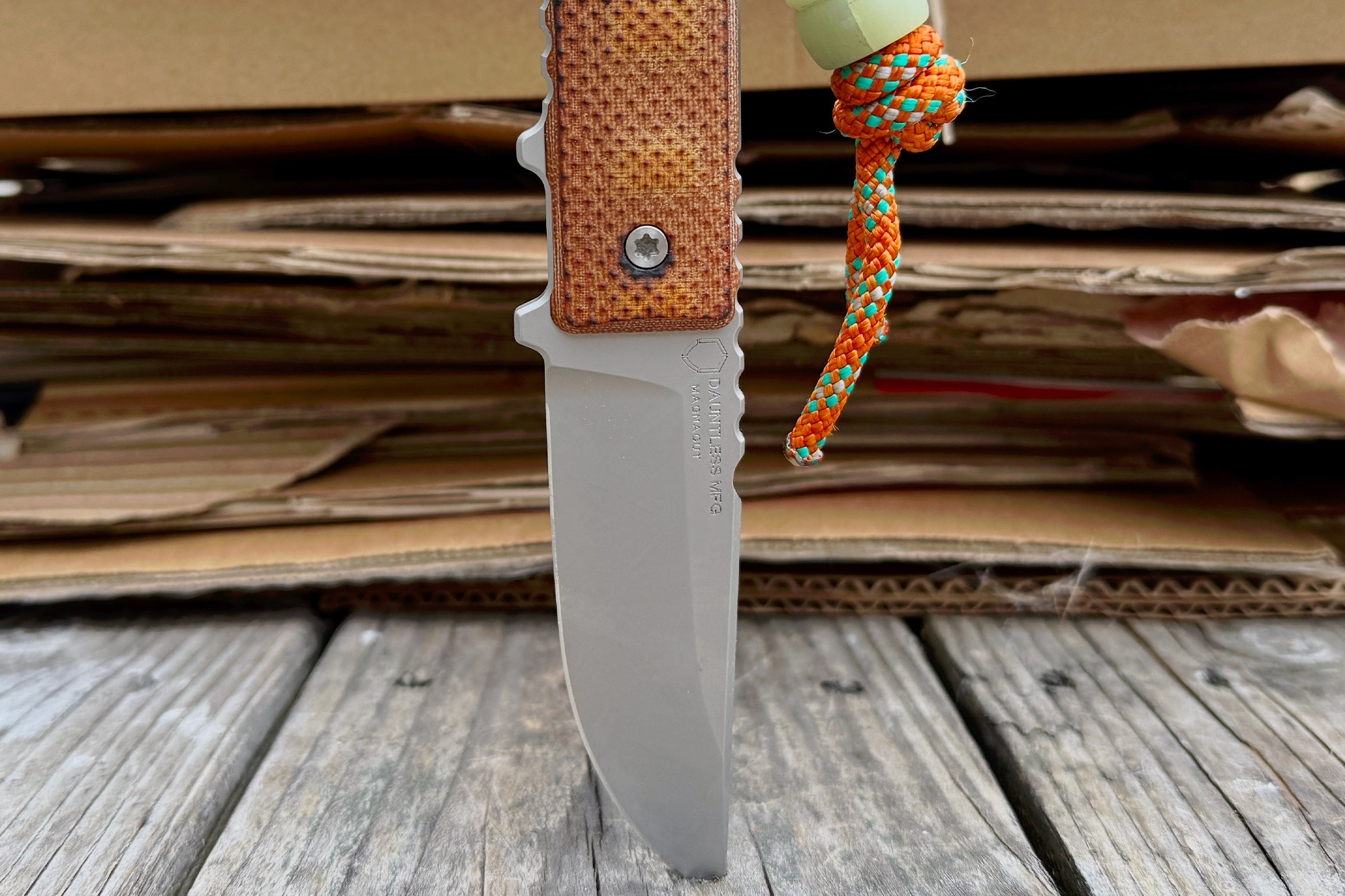 Dauntless Manufacturing Hiker with orange paracord, displayed against a cardboard background