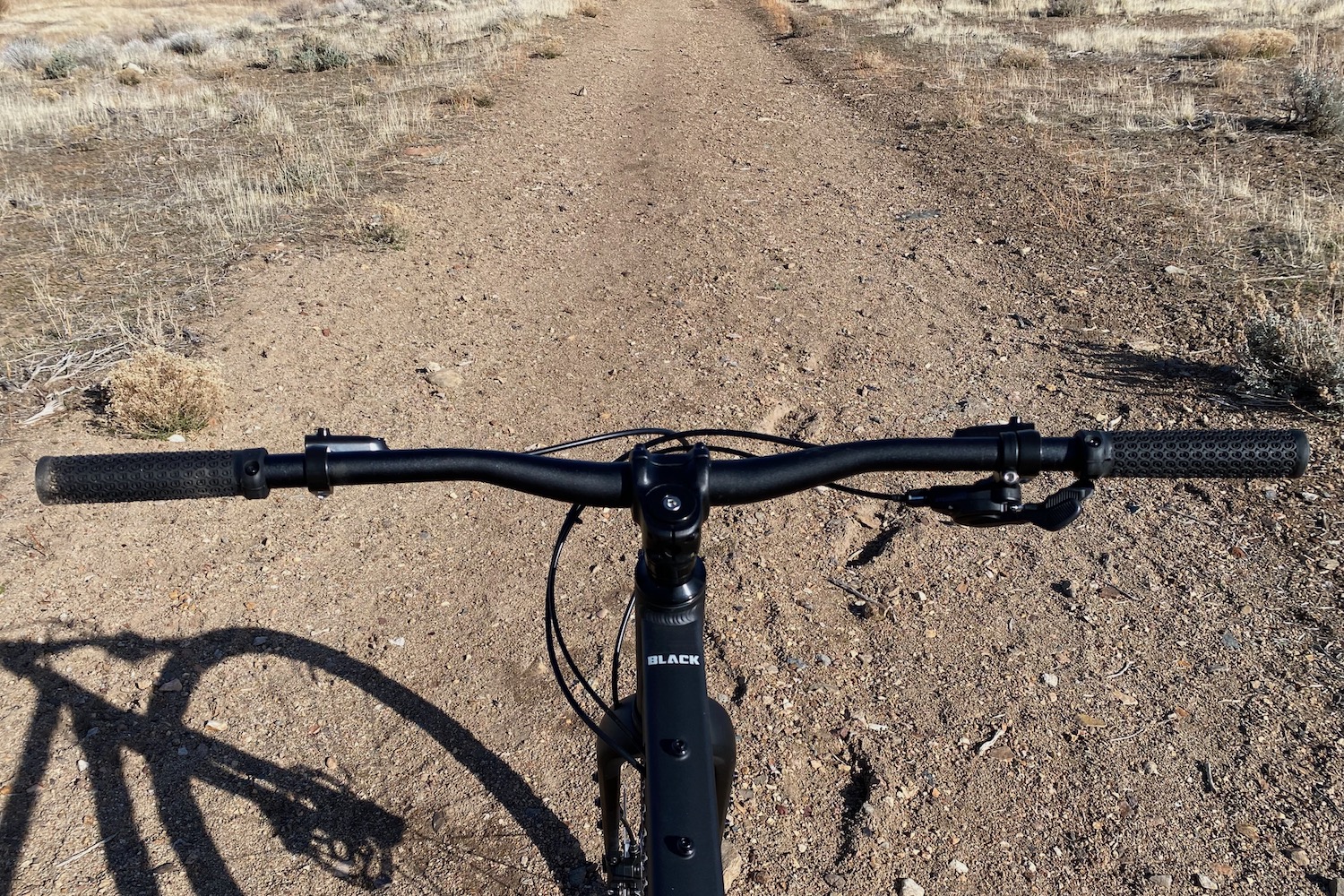 Looking over the Eaglebear bike's handlebar down a smooth gravel road
