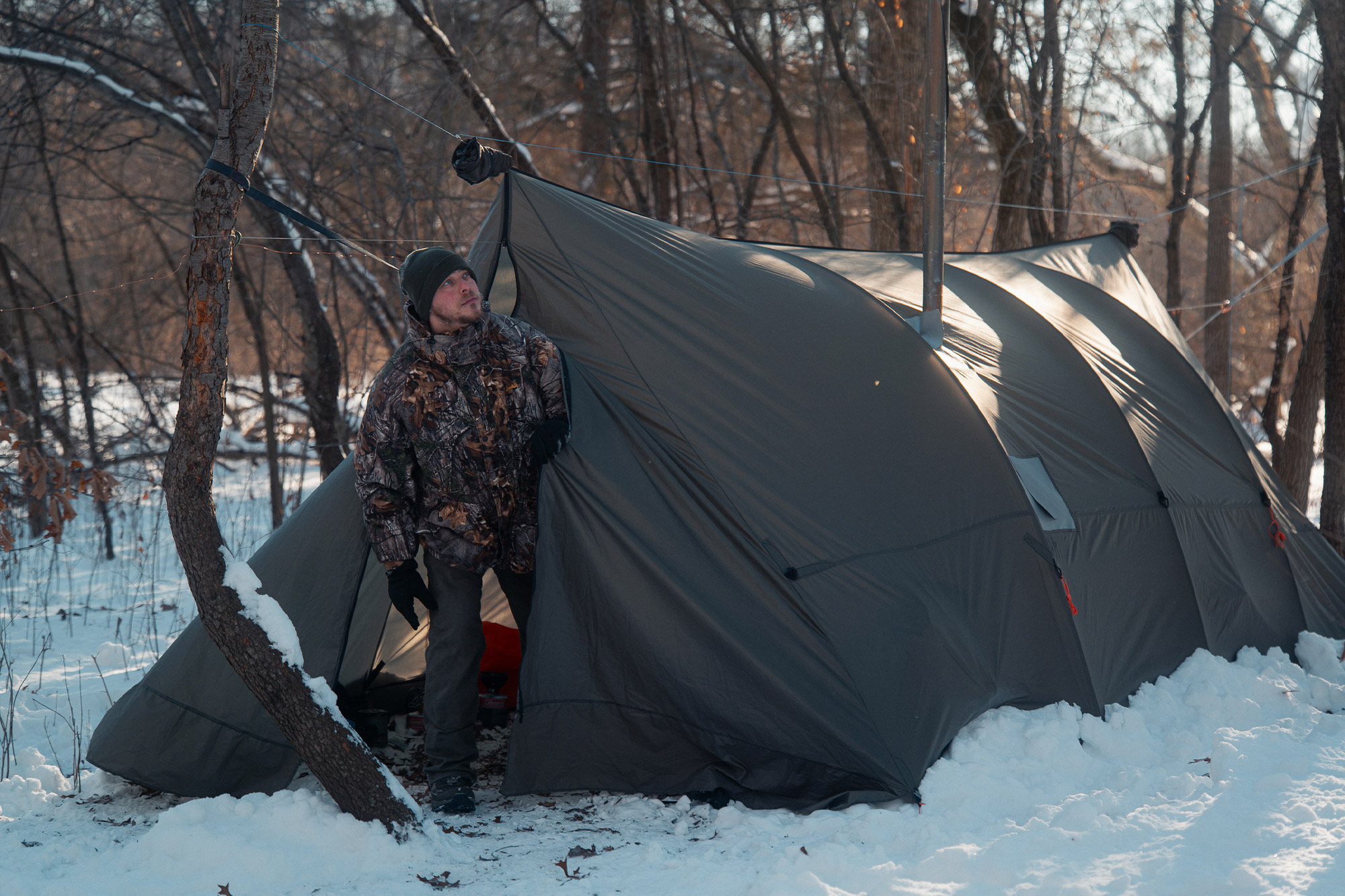 Camper steps out of the Warbonnet Tsunami tarp into a snowy forest