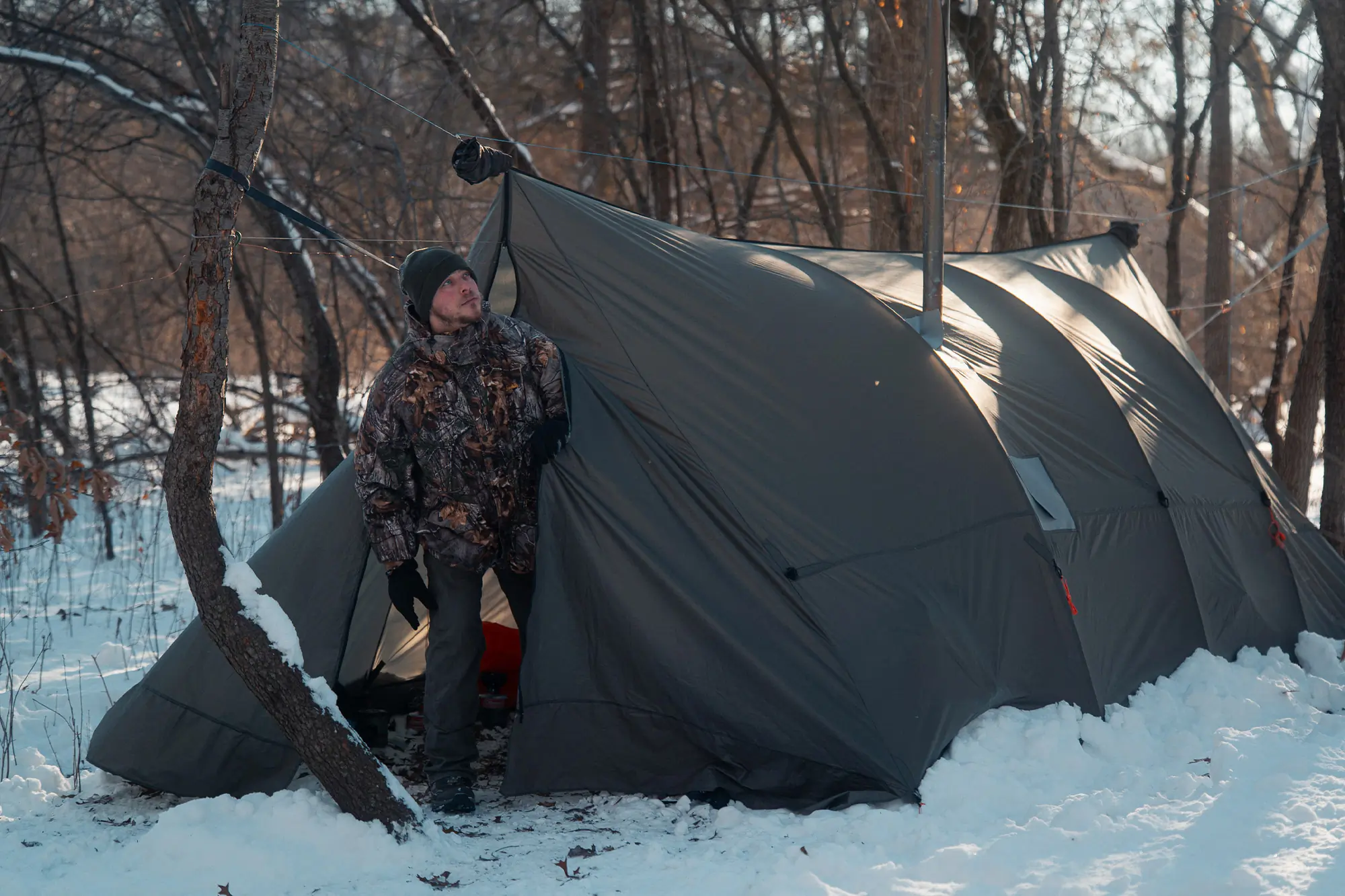 Camper steps out of the Warbonnet Tsunami tarp into a snowy forest