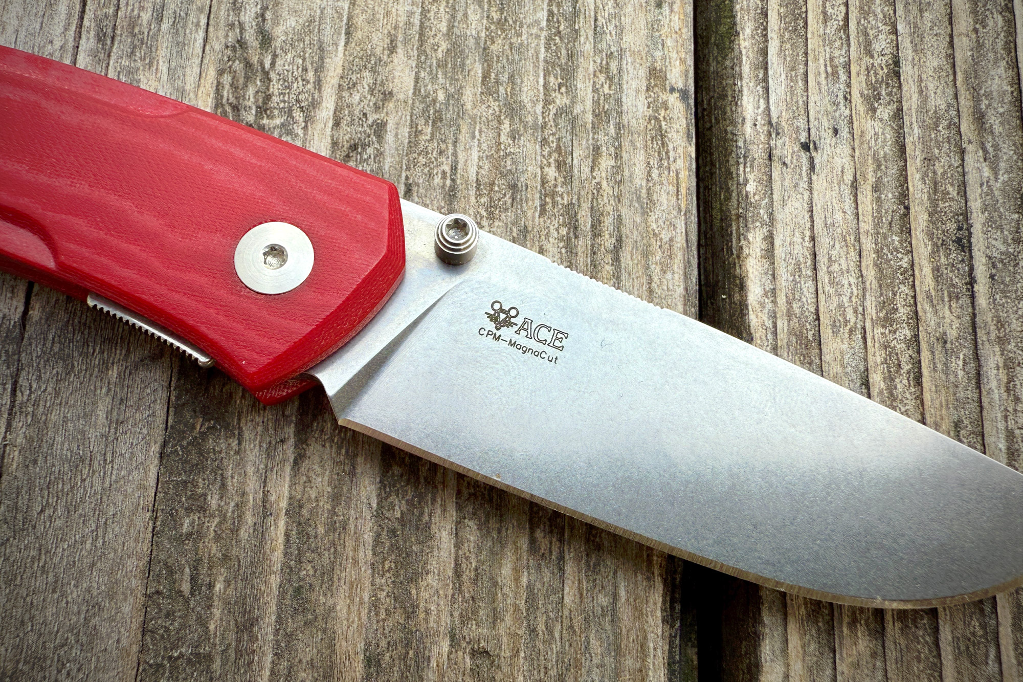 Close-up of the GiantMouse Iona V2 knife, focusing on the engraved ACE logo on the blade near the handle